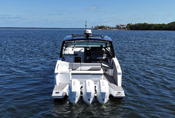 2020 Cruisers Yachts 38 GLS OB on water, rear view with triple outboard engines.