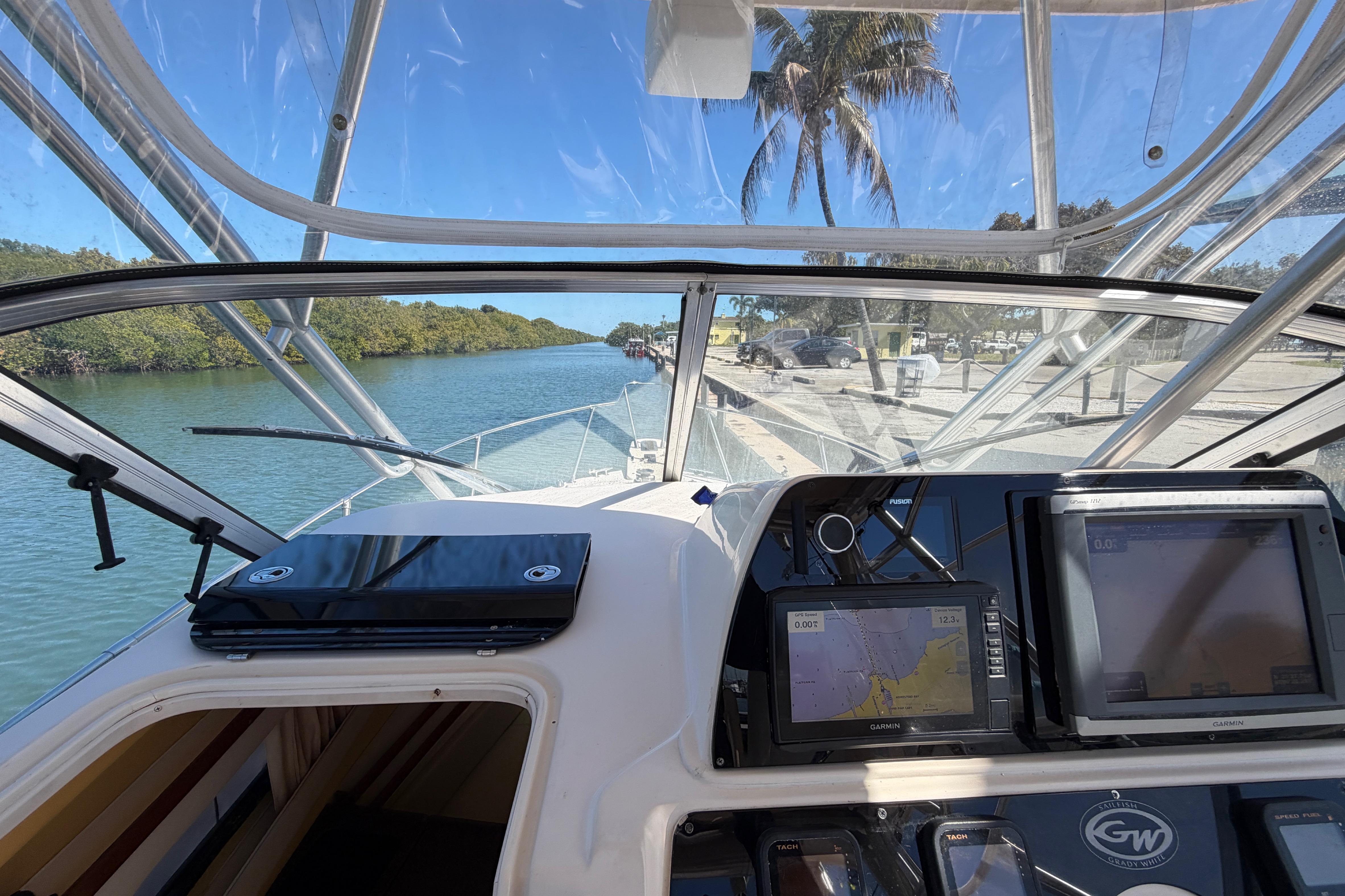 2006 Grady-White Sailfish 282 boat cockpit view with navigation equipment, docked by a scenic waterway.