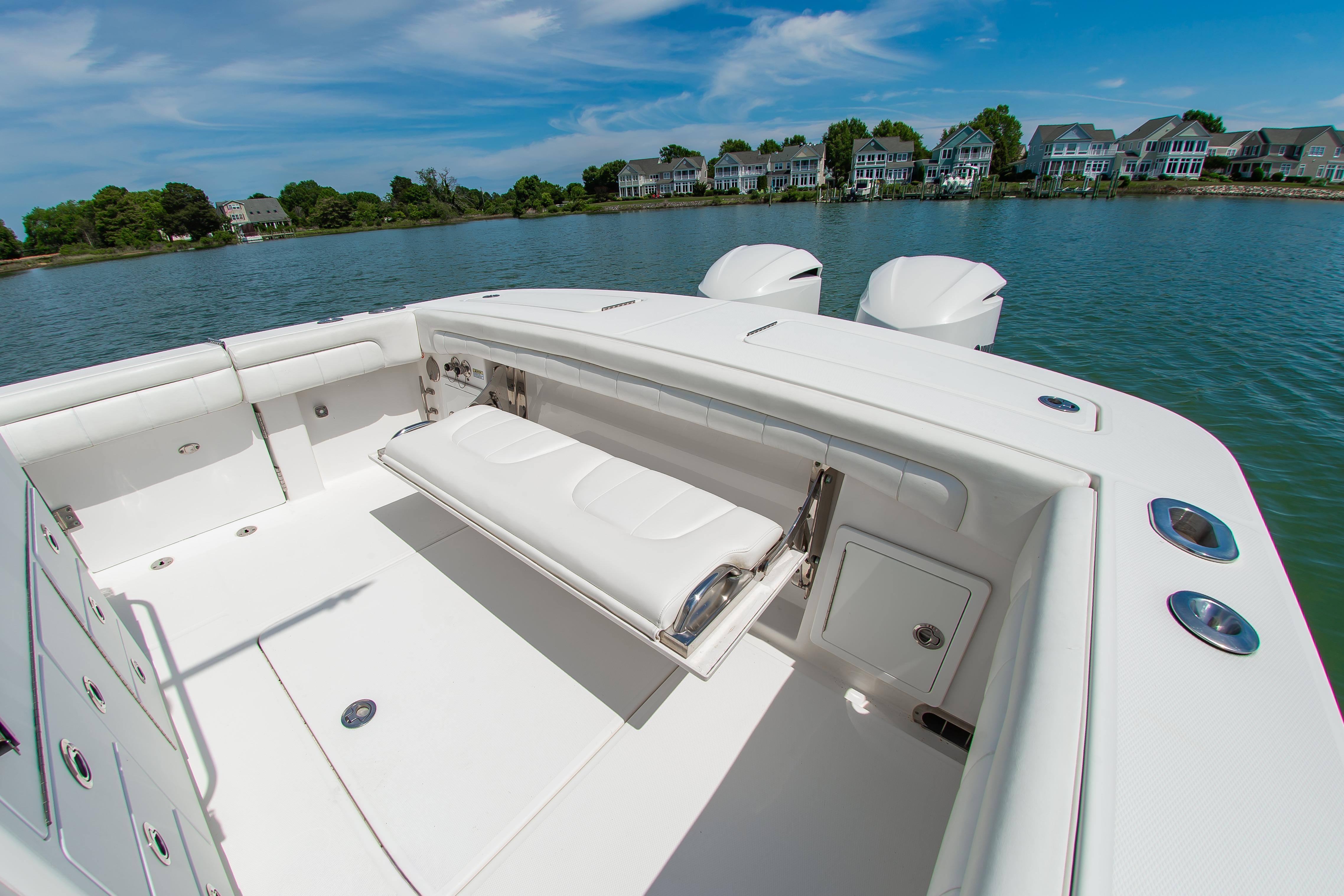 2019 Regulator 31 boat with white seating, docked near waterfront homes.