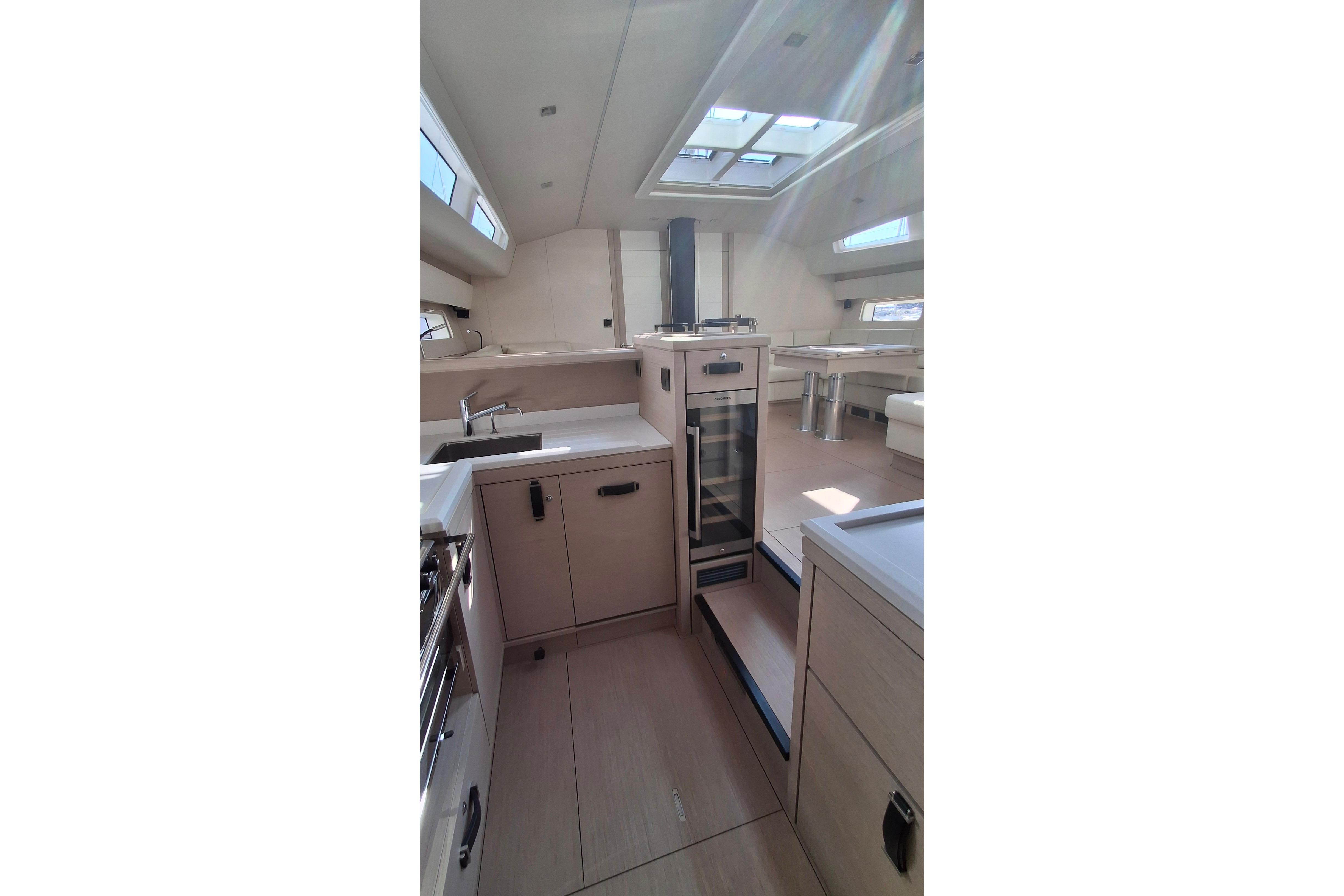 Luxurious interior of 2025 Jeanneau 65 yacht, featuring modern kitchen and dining area.
