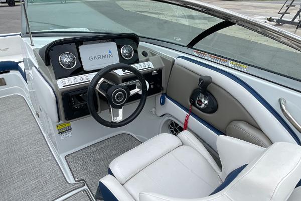 2023 Crownline E235 boat interior with Garmin navigation, steering wheel, and comfortable seating.