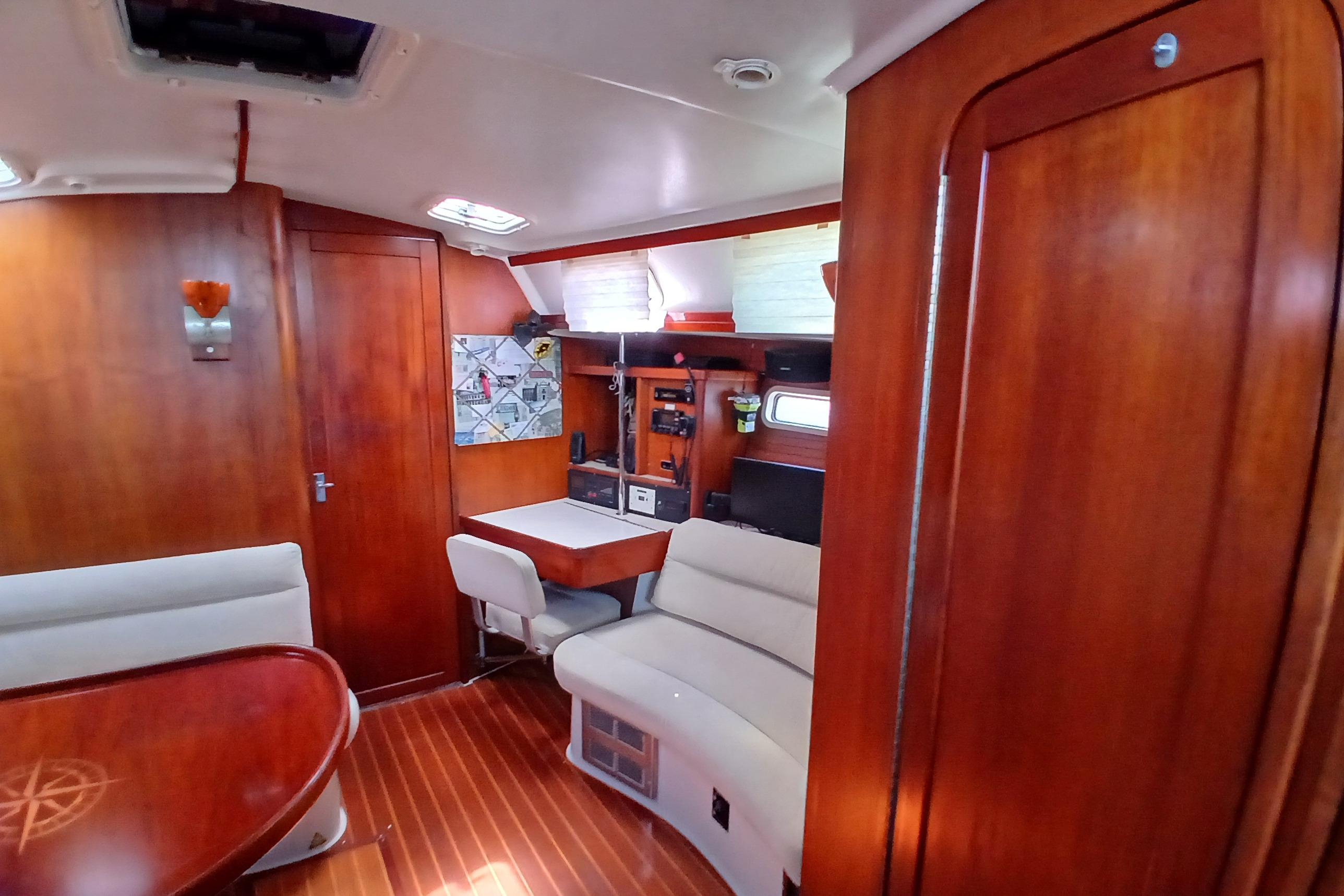 Interior of a 1995 Catalina 42 MkII sailboat with wooden finishes and cozy seating area.