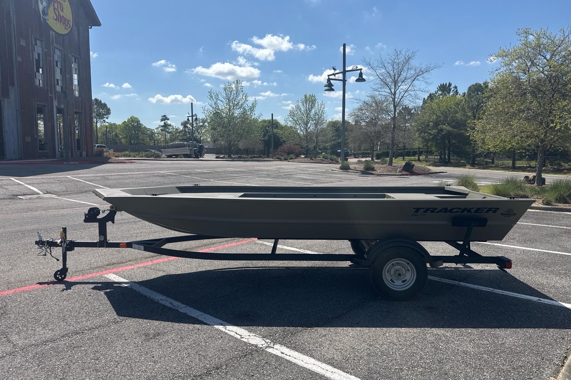 2026 Tracker Grizzly 1754 Utility boat on trailer in parking lot.