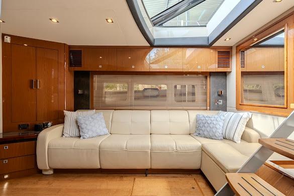 Luxurious interior of 2016 Sea Ray Sundancer 510 yacht with cream sofa and skylight.