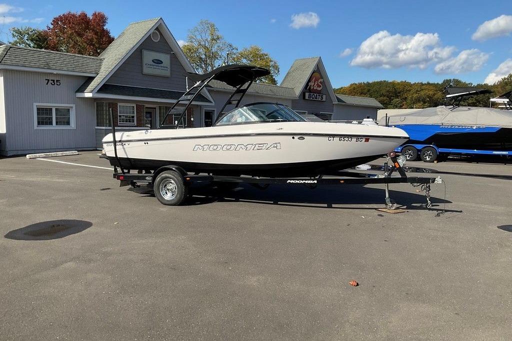 2015 Moomba Outback V boat on trailer at dealership, sunny day.