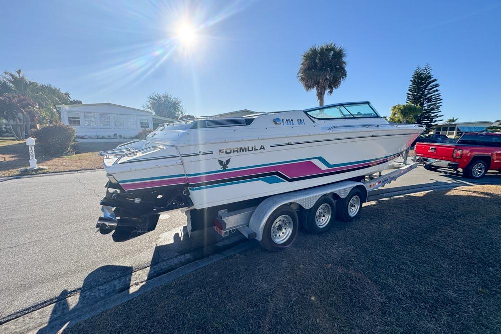 1989 Formula 292 SR-1 boat on trailer, parked in sunny residential area.