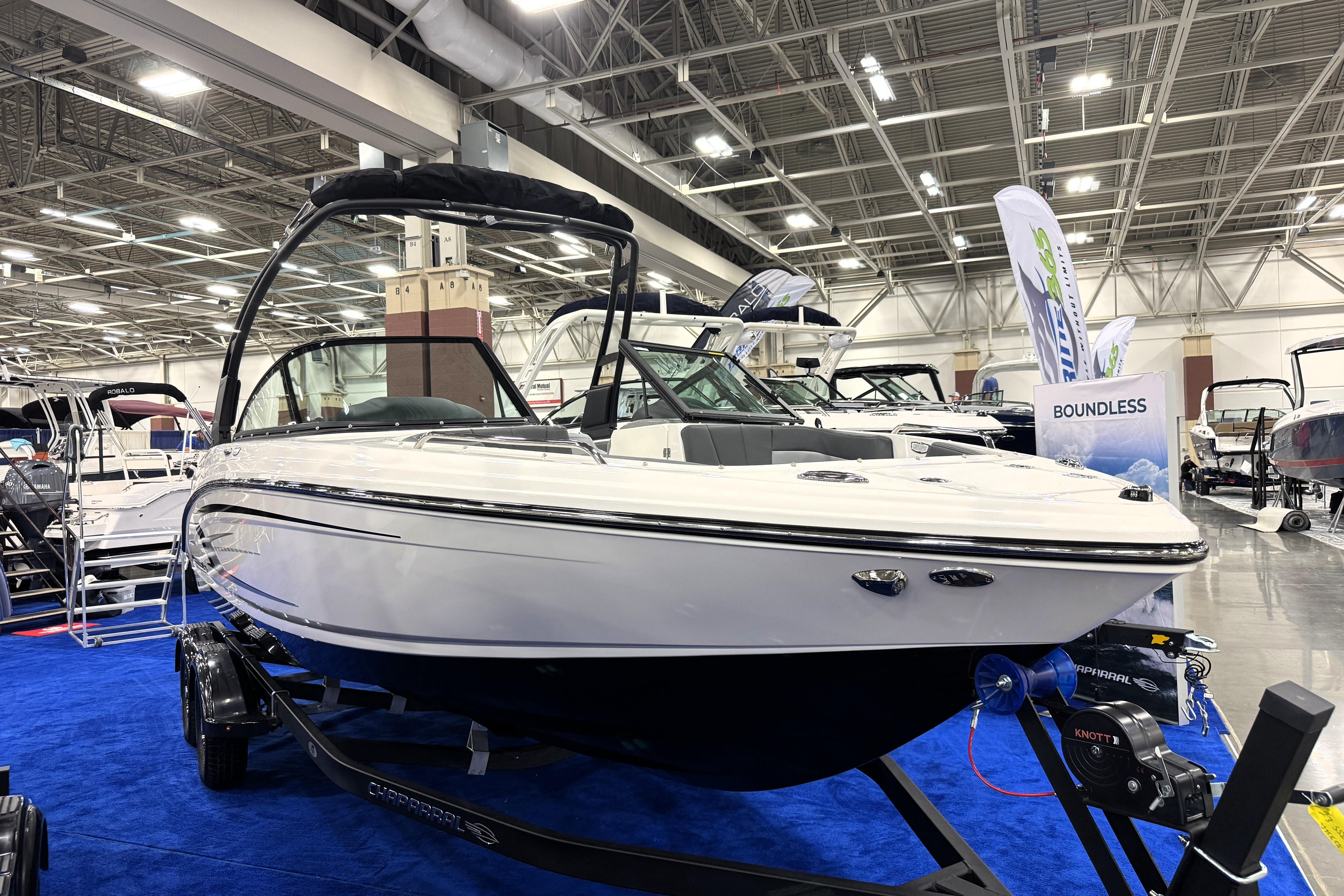 2026 Chaparral 23 SSi boat displayed indoors on blue carpet.