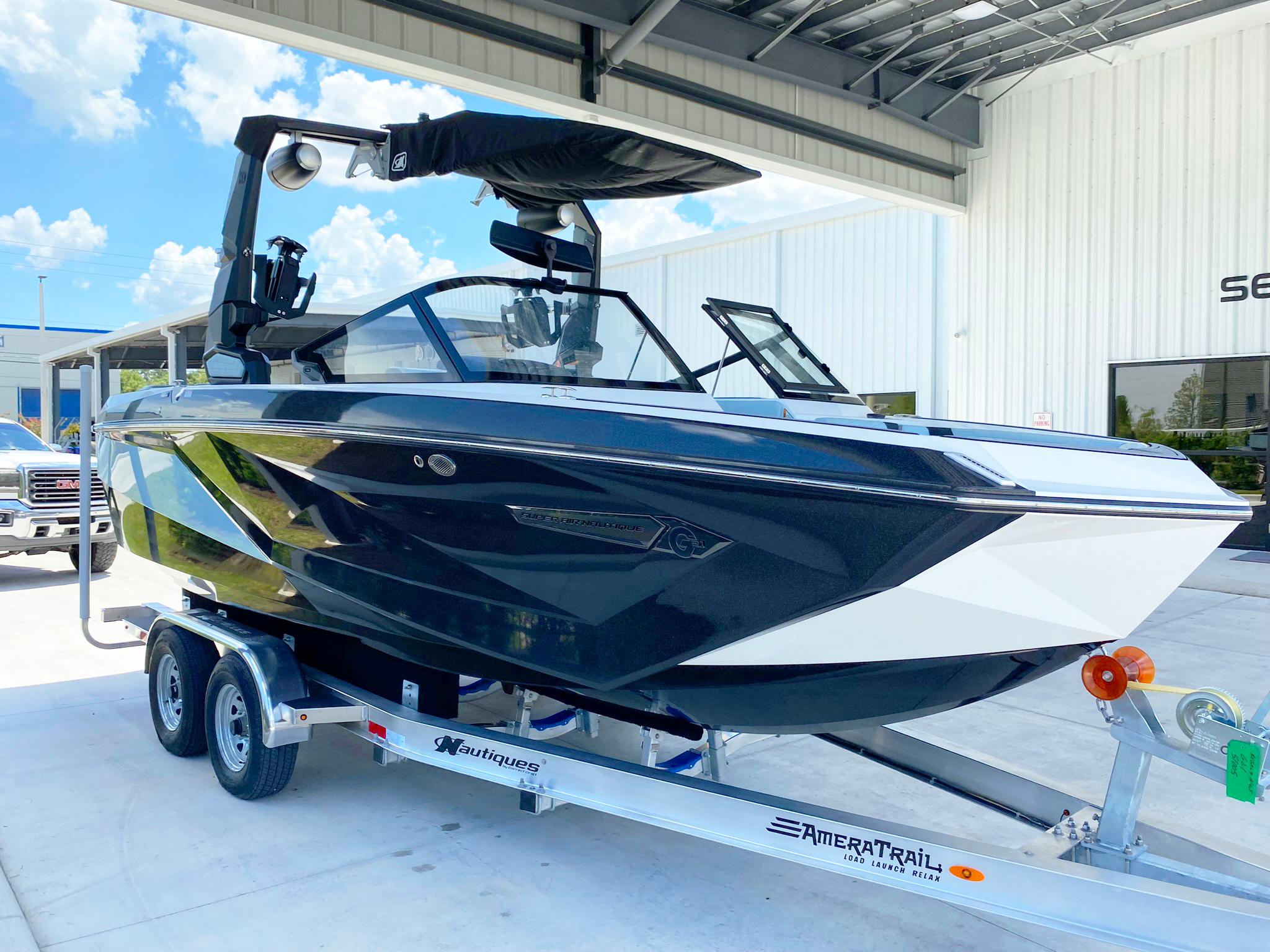 2024 Nautique Super Air Nautique G21 boat on trailer, parked outdoors under a canopy.