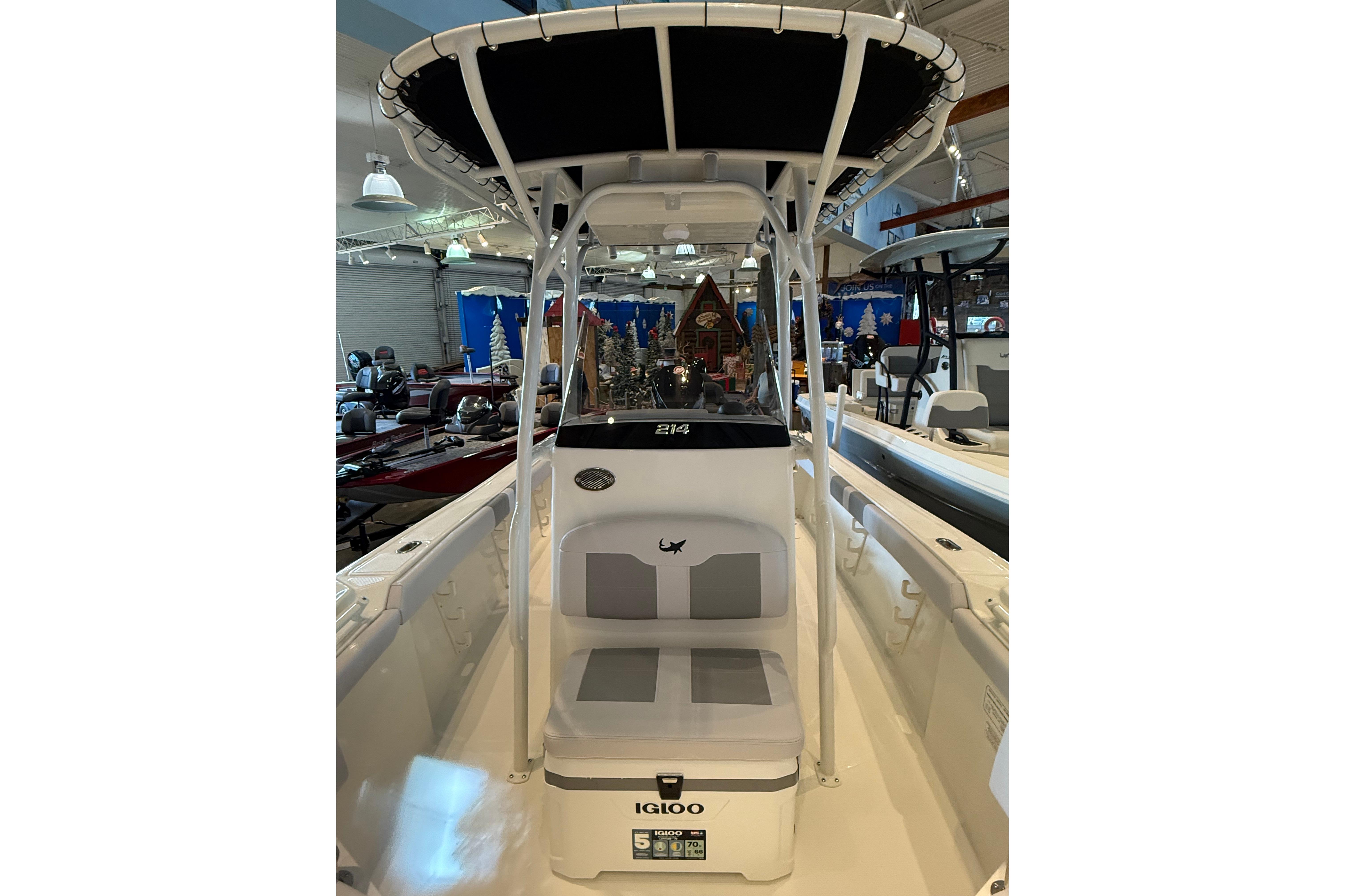 2026 Mako 214 Center Console boat with T-top and Igloo cooler in showroom.