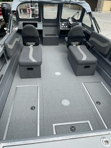 2025 Spartan 200 Astoria boat interior with gray seating and storage compartments.
