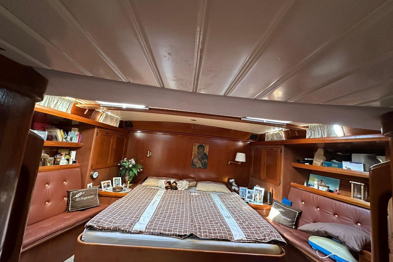 Luxurious cabin interior of 1989 North Wind 56 yacht with cozy bed and wooden decor.