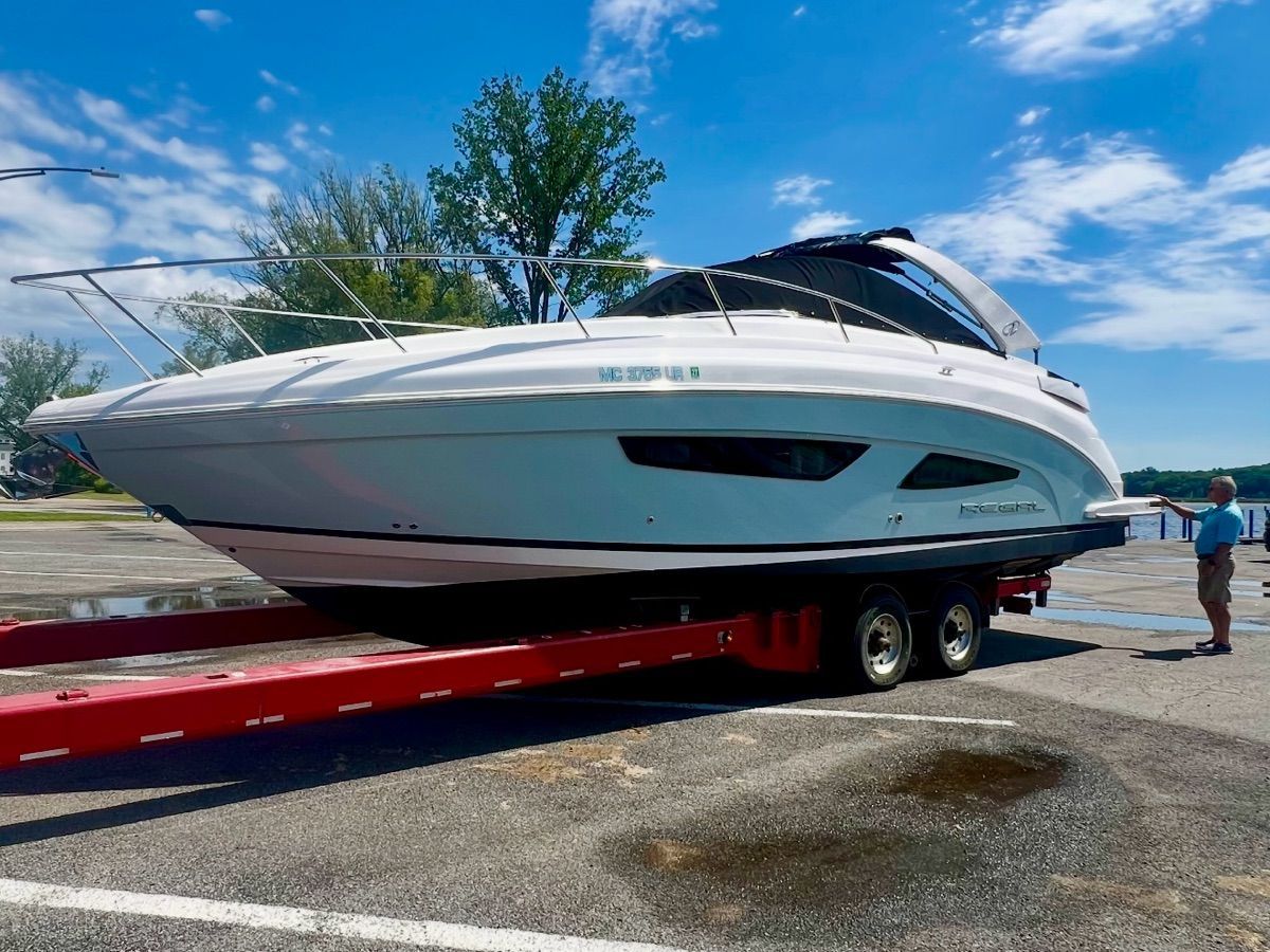 A 2021 Regal 33 Express boat on a trailer on land.