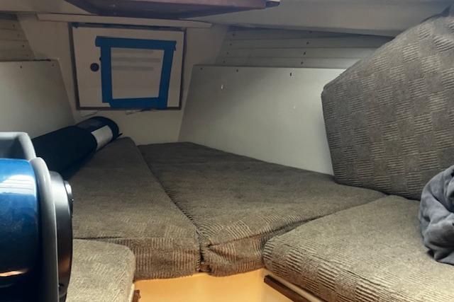 Interior cabin of a 1979 Pearson 365 Ketch sailboat with cushioned seating.