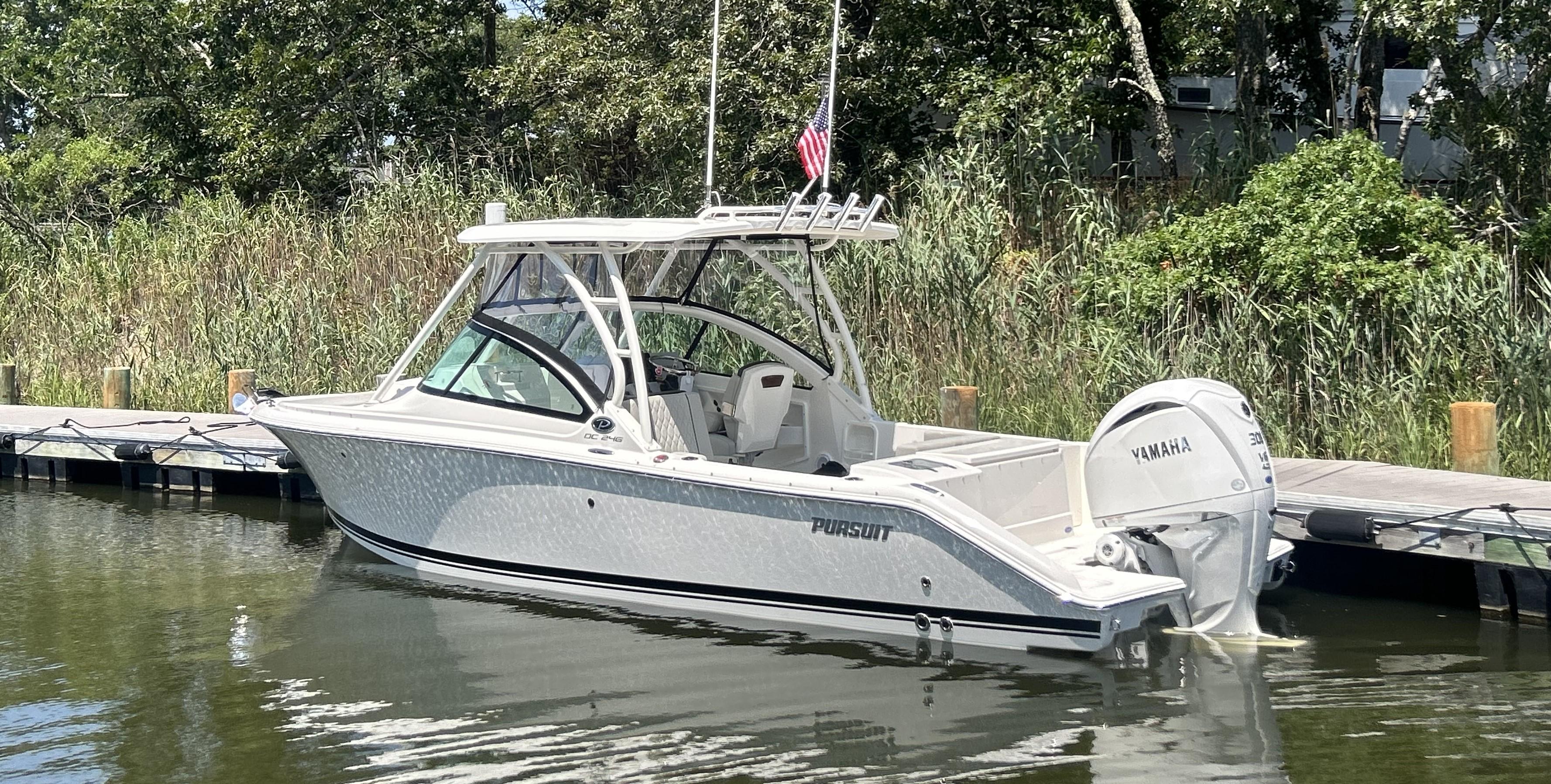 2026 Pursuit DC 246 Dual Console boat docked with Yamaha engine.