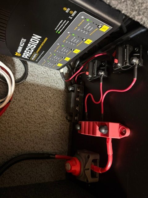 Boat's electrical system with cables and fuses, including a Minn Kota Precision charger.