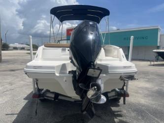 2022 Bayliner VR6 boat with outboard motor, parked outdoors under a blue sky.
