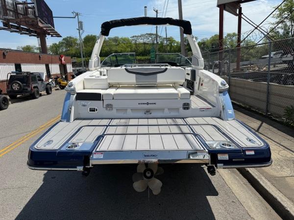 2023 Chaparral 267 SSX boat, rear view, parked on street, showcasing swim platform and seating.
