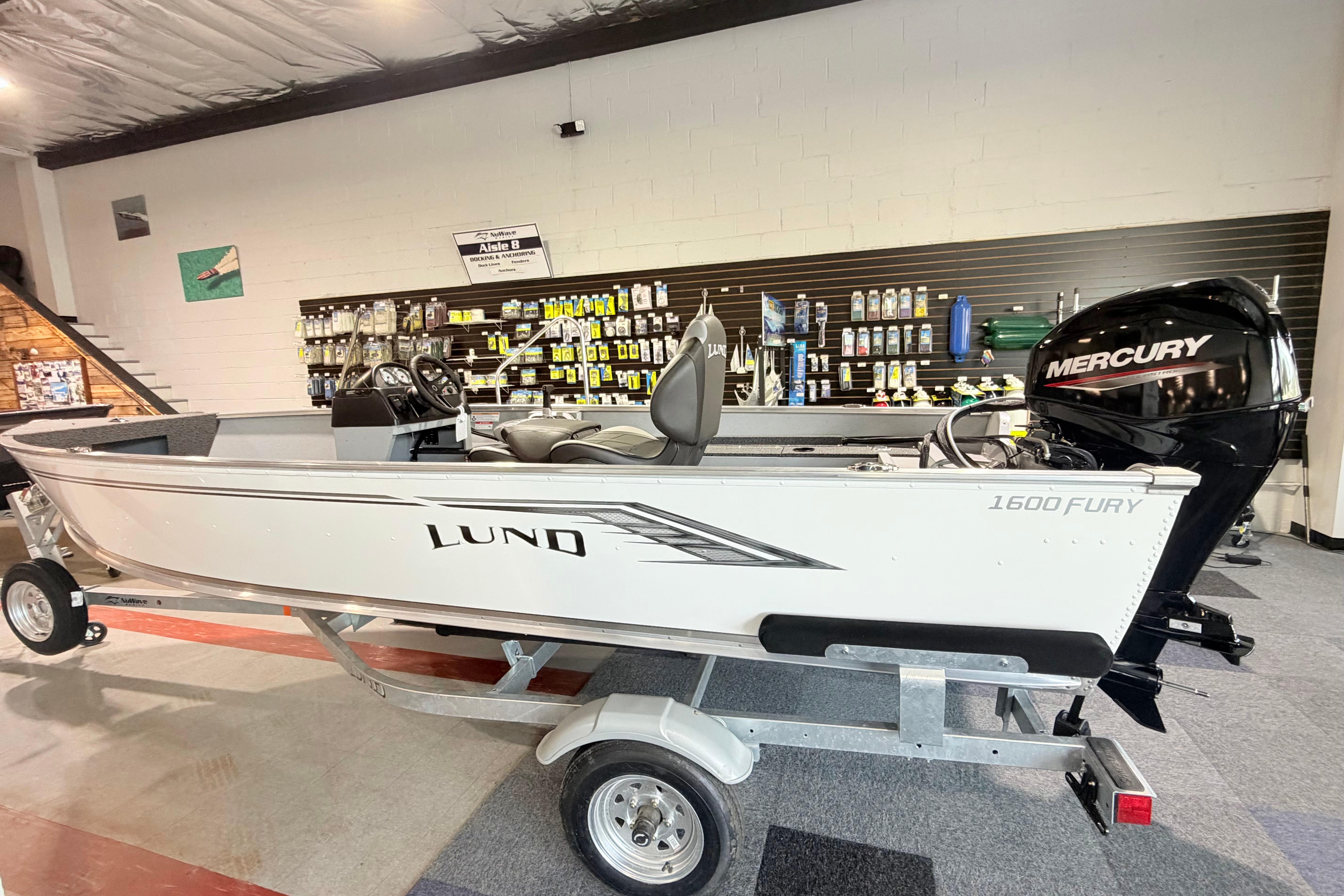 2027 Lund 1600 Fury SS fishing boat with Mercury engine displayed in showroom.