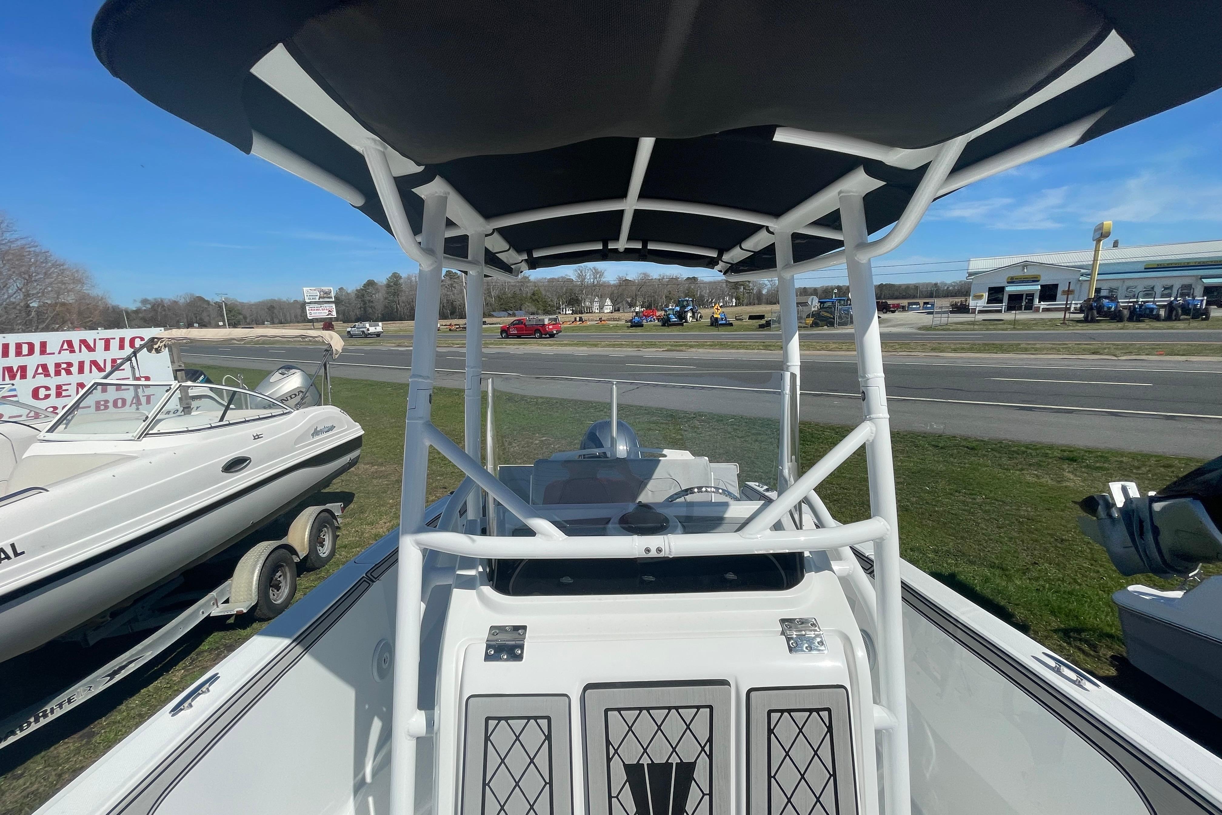 2022 Wellcraft 202 Fisherman boat with T-top, displayed outdoors at a marine center.