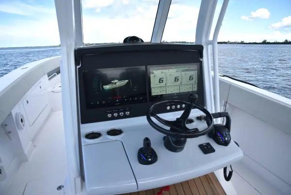 Manufacturer Provided Image: 2026 Jupiter 380LS boat dashboard with dual screens and steering wheel on open water.