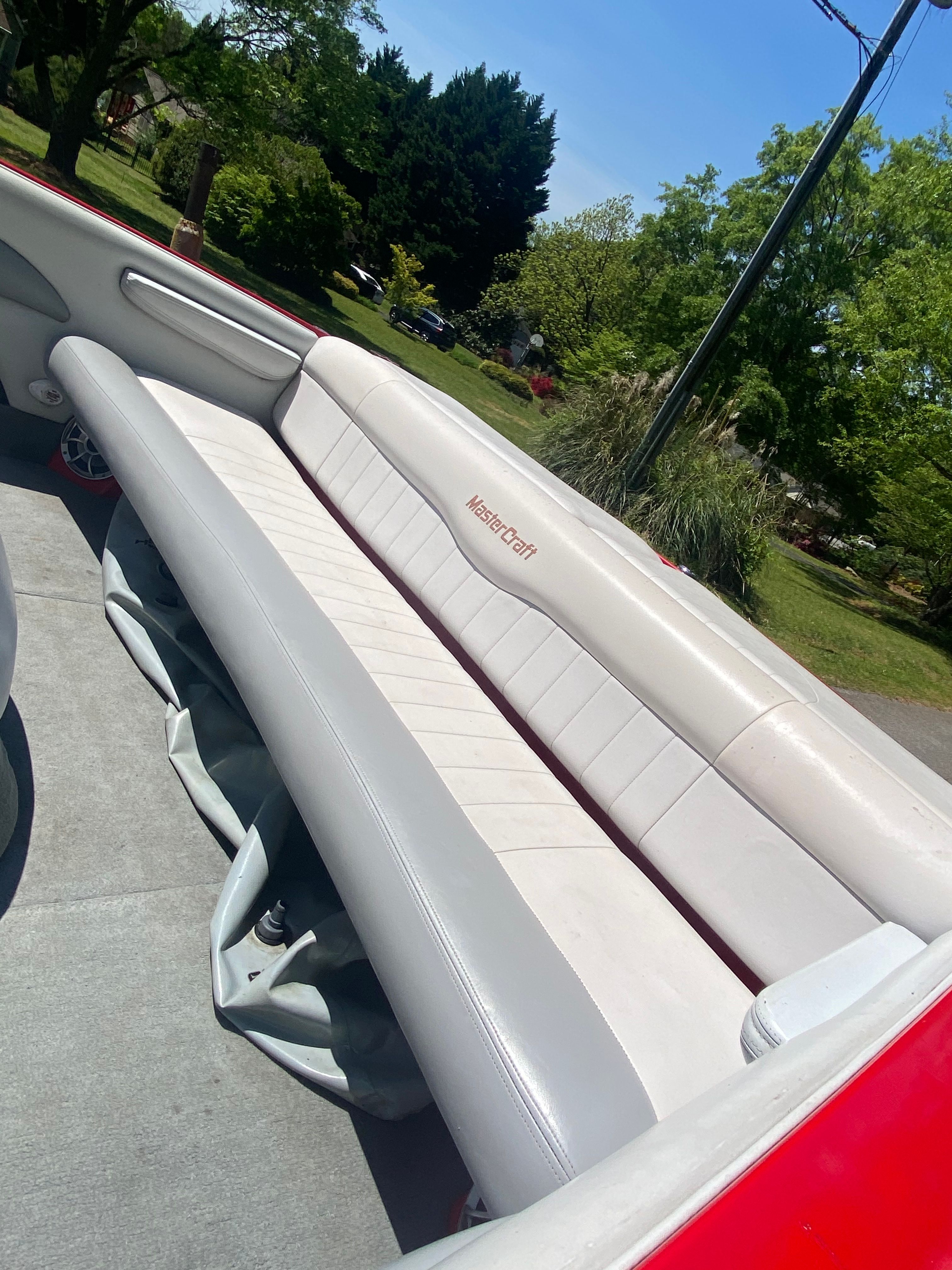 The image shows the seating area of a 2004 MasterCraft X-9 boat with white upholstery.