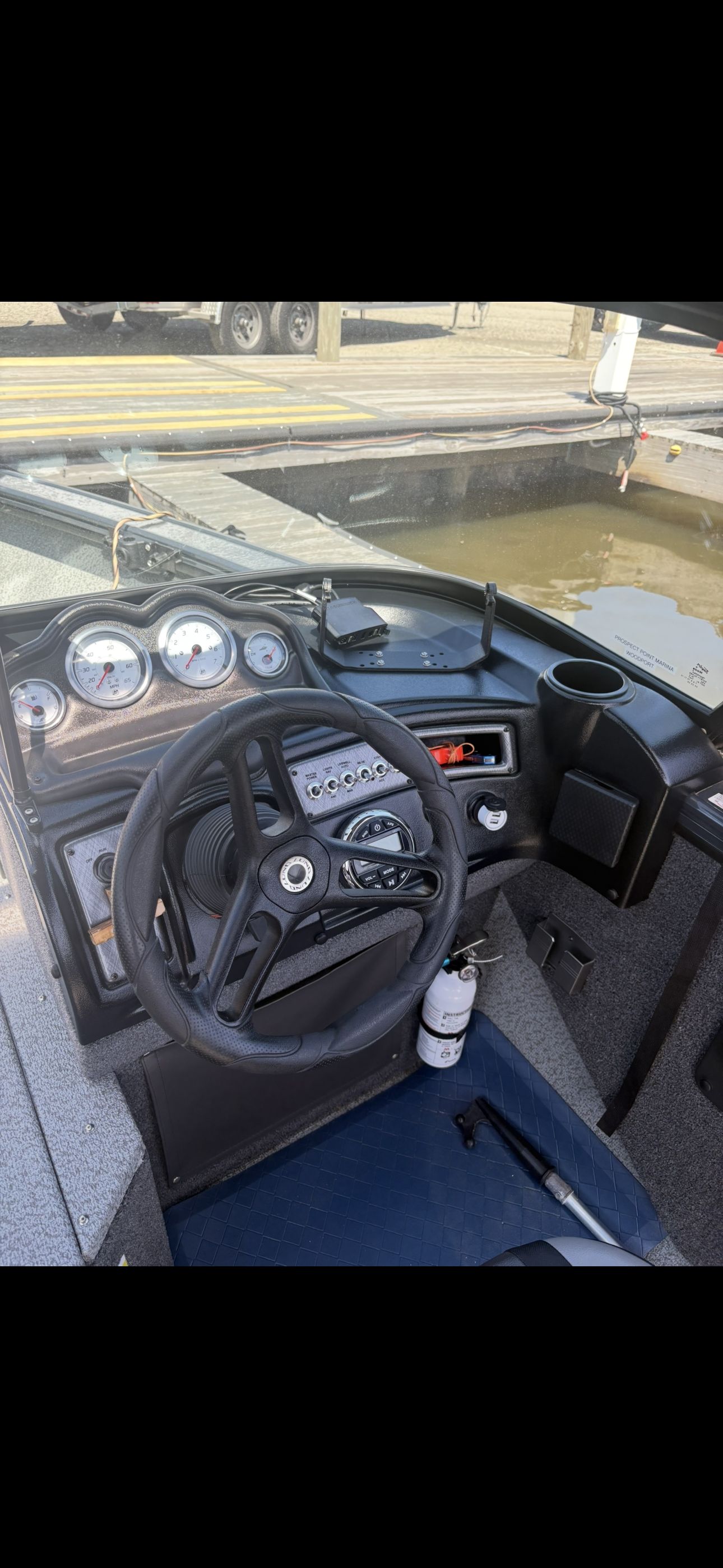 The image shows the cockpit of a Lund Fisherman 2075 boat with controls and instruments.