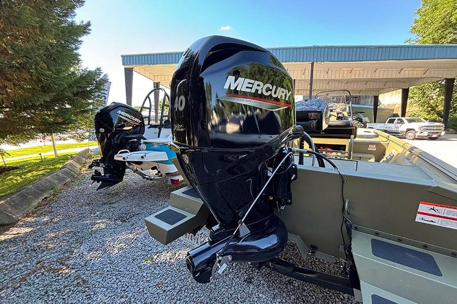 2022 Lowe Roughneck 1660 boat with Mercury outboard motor, parked on gravel under a canopy.