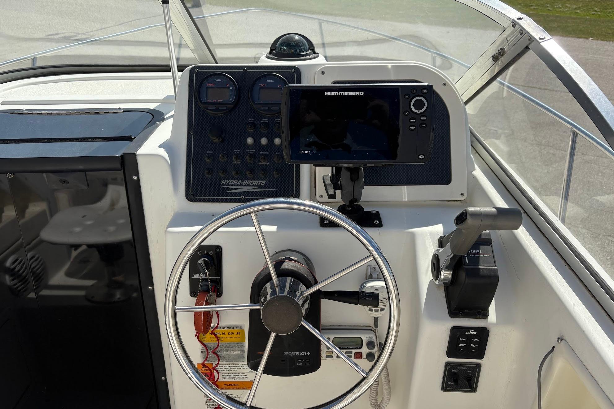 2002 Hydra-Sports 212 WA boat dashboard with steering wheel and navigation equipment.