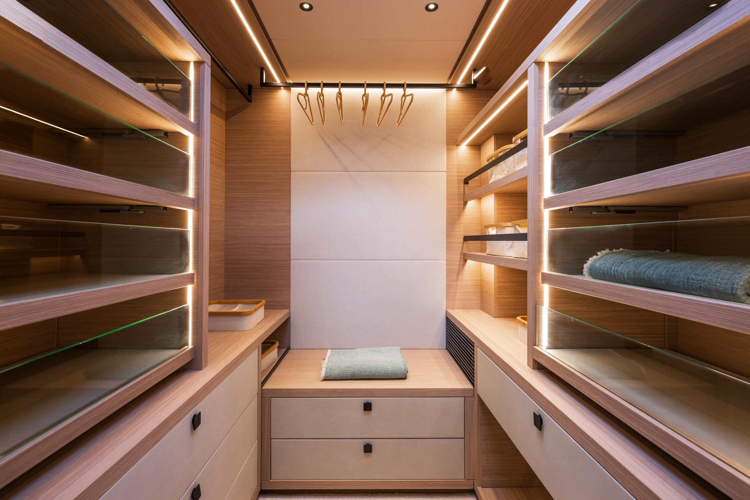Luxurious walk-in closet on Lagoon Eighty 2 yacht, featuring wooden shelves and modern lighting, 2025 model.