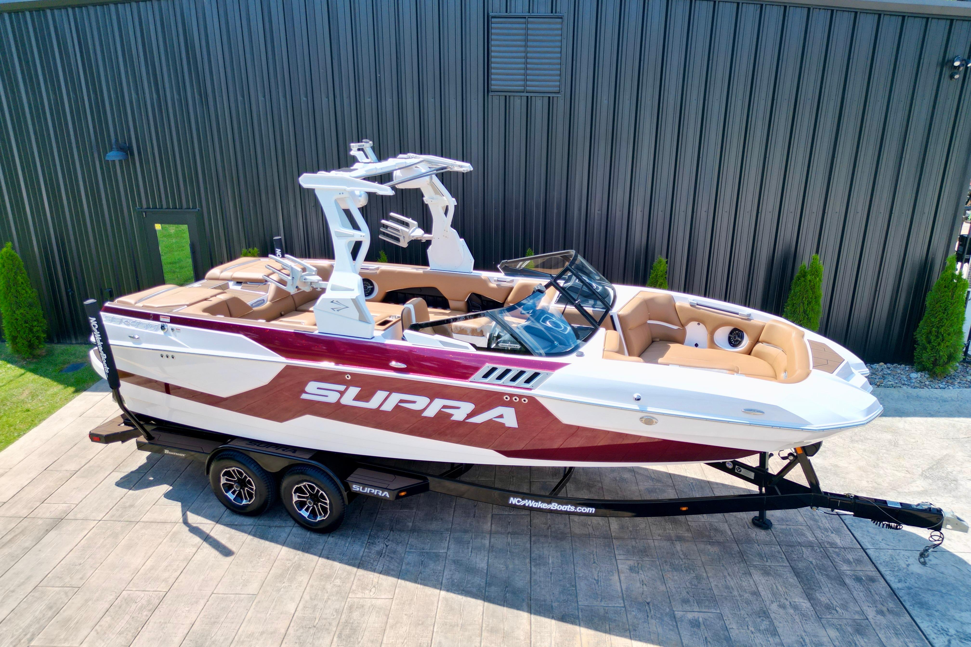 2021 Supra SE boat on trailer, parked outdoors, showcasing sleek design and luxury features.