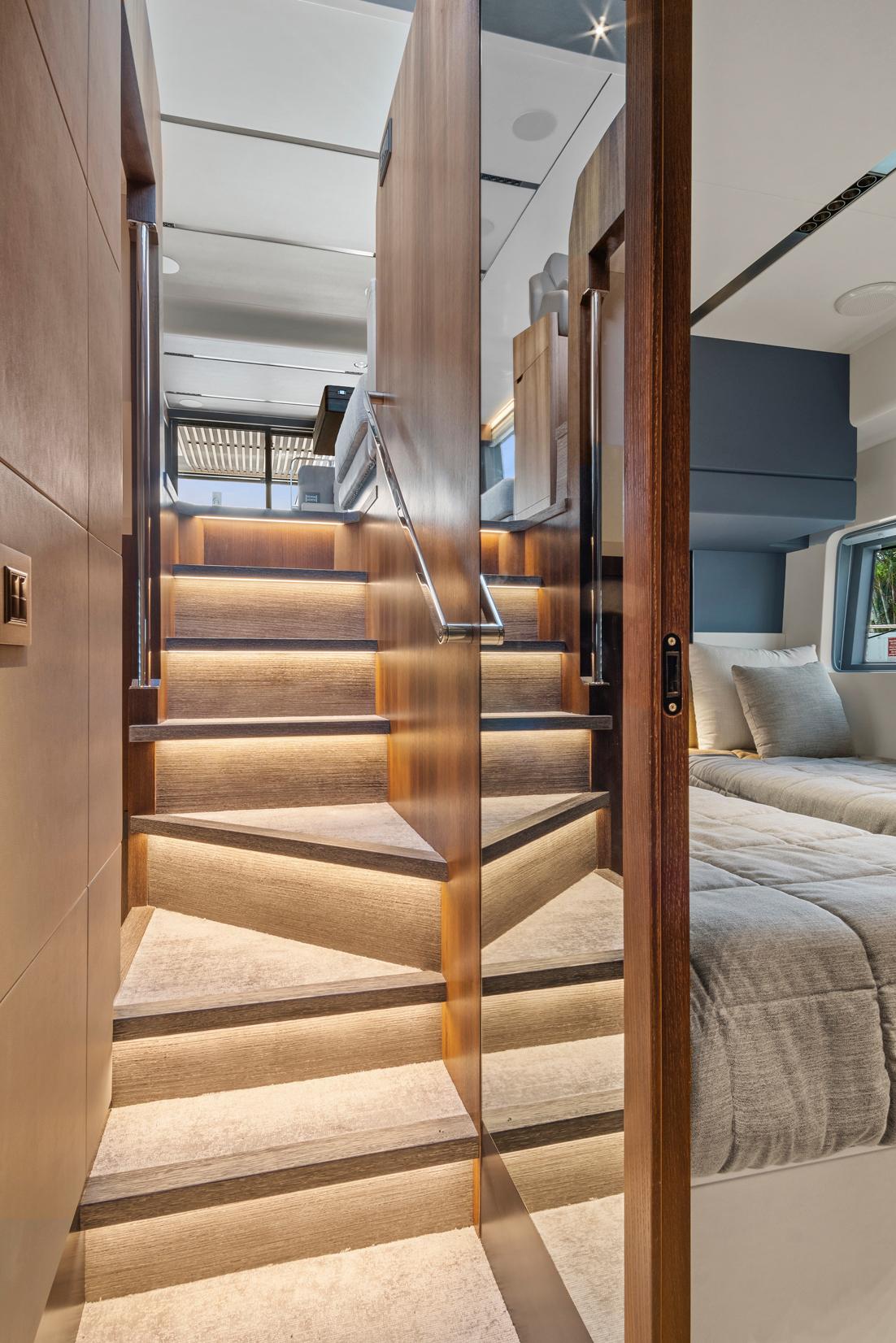 Luxurious interior of 2023 Astondoa AS5 yacht with elegant wooden staircase and modern bedroom.