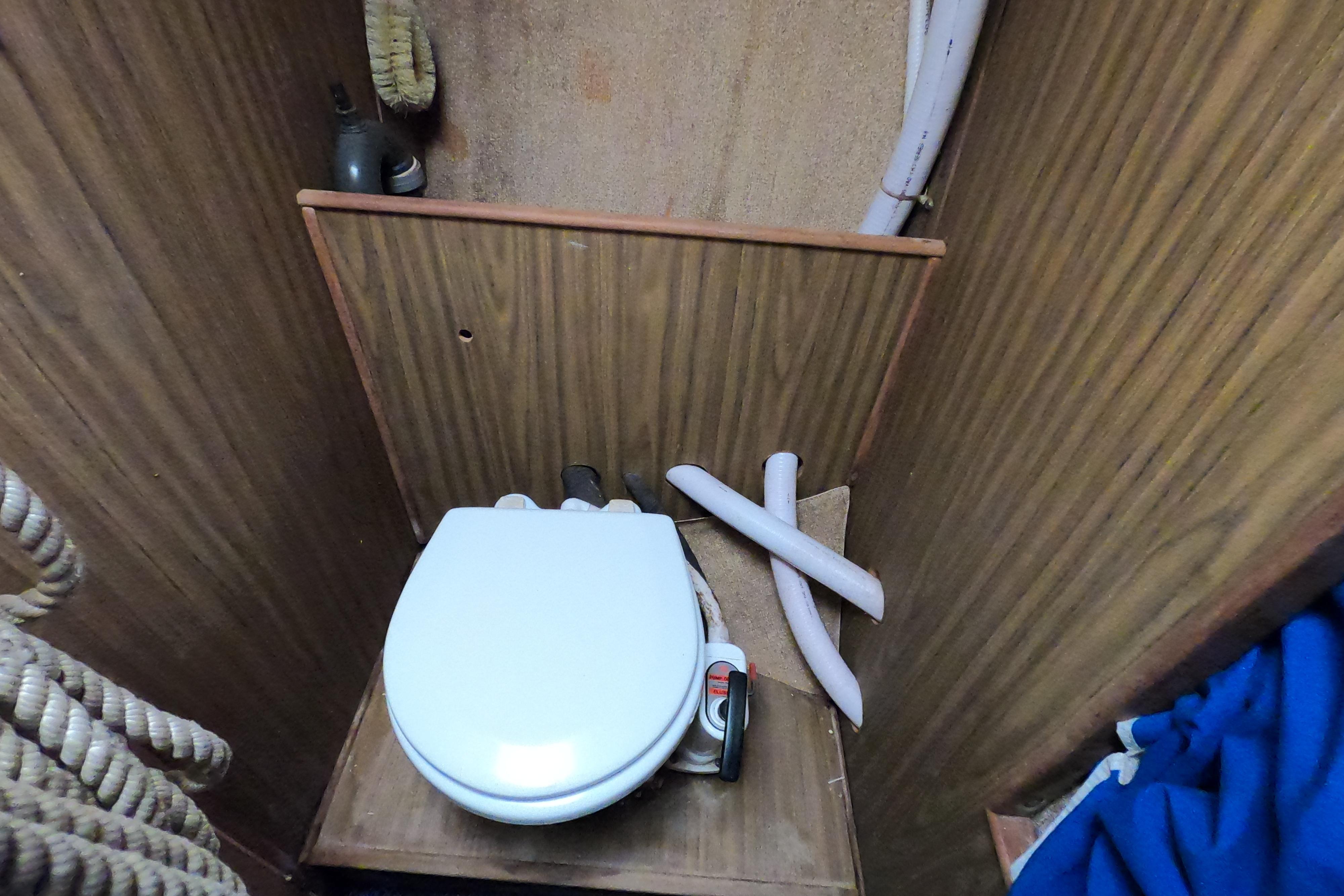 1972 Morgan 27 boat interior with compact marine toilet and wooden paneling.