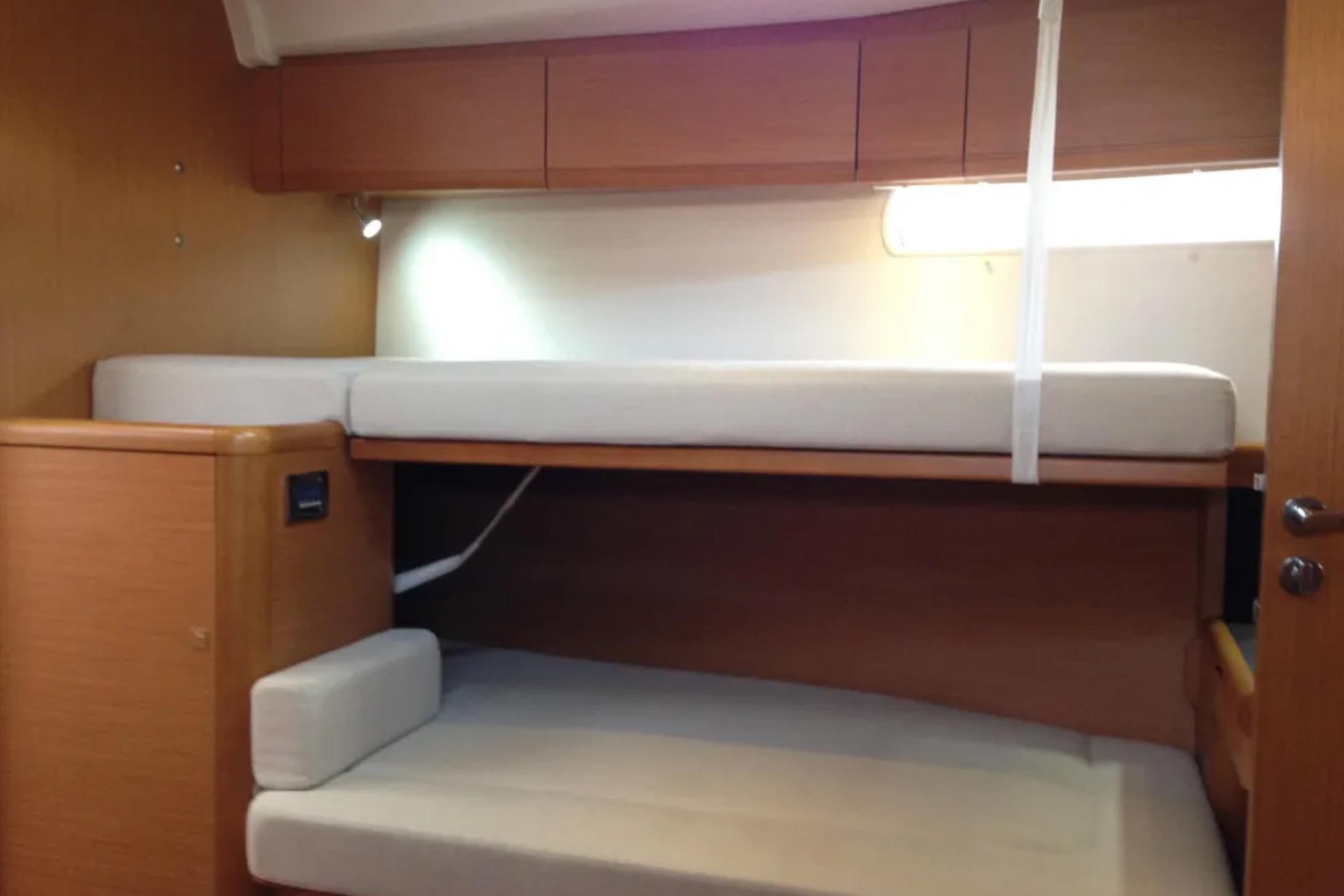 Interior cabin of 2011 Jeanneau 57 yacht with bunk beds and wooden finish.