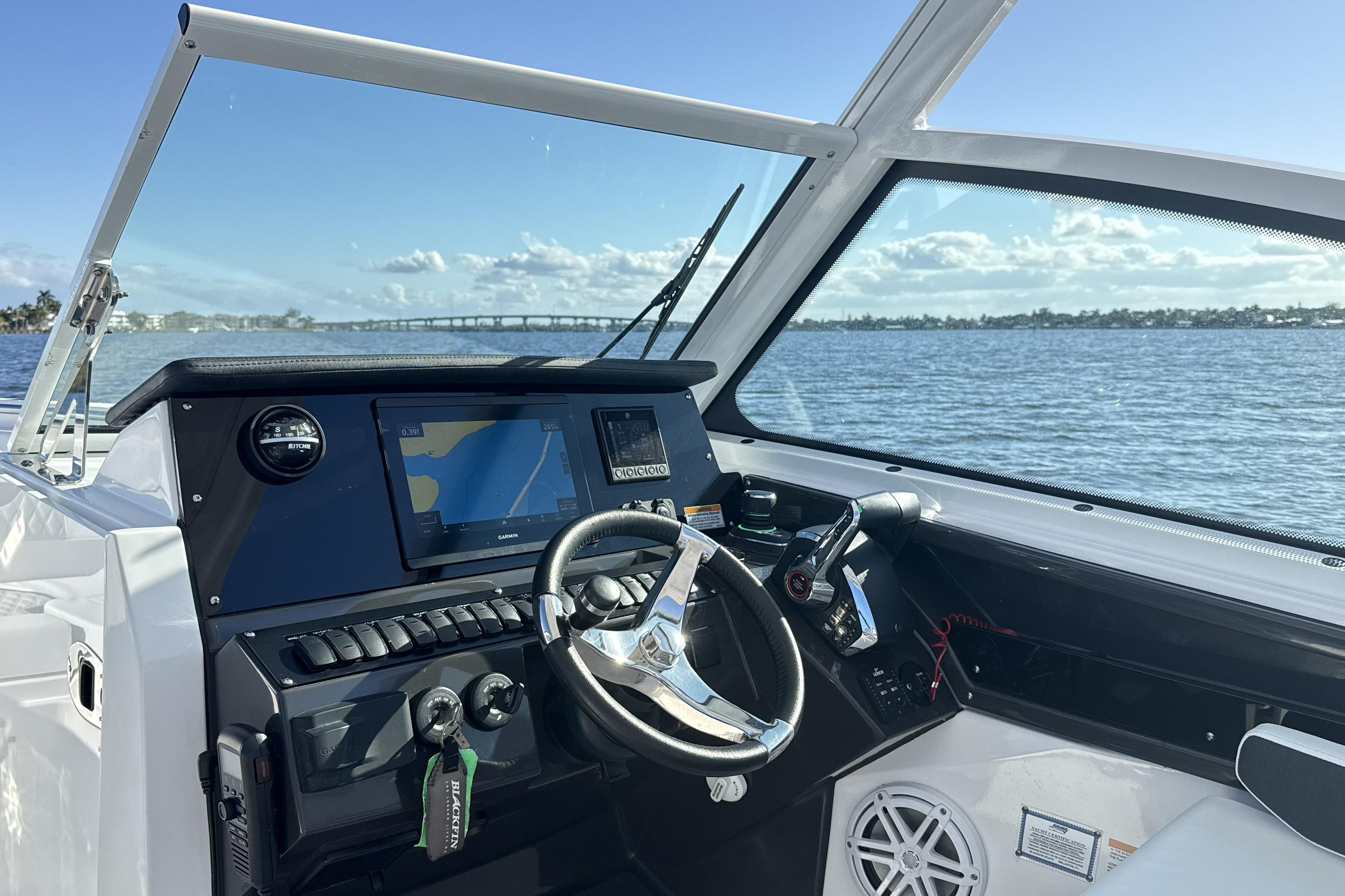 2025 Blackfin 272 DC boat dashboard with navigation system, steering wheel, and water view.