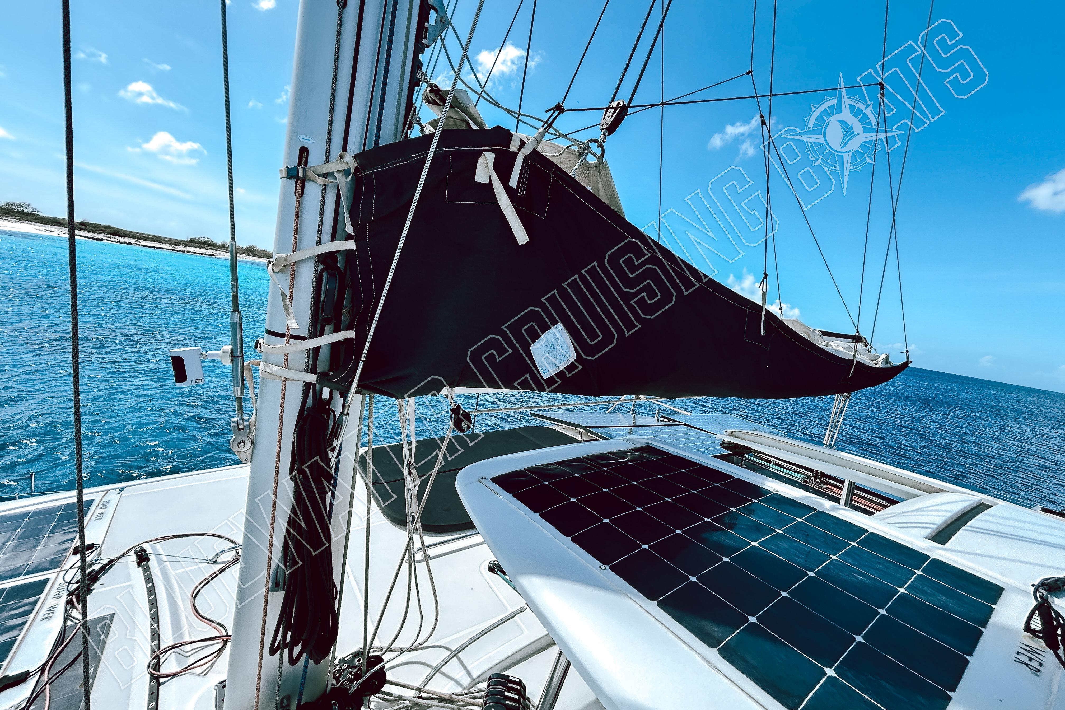 2018 Lagoon 42 catamaran with solar panels, anchored in clear blue waters.