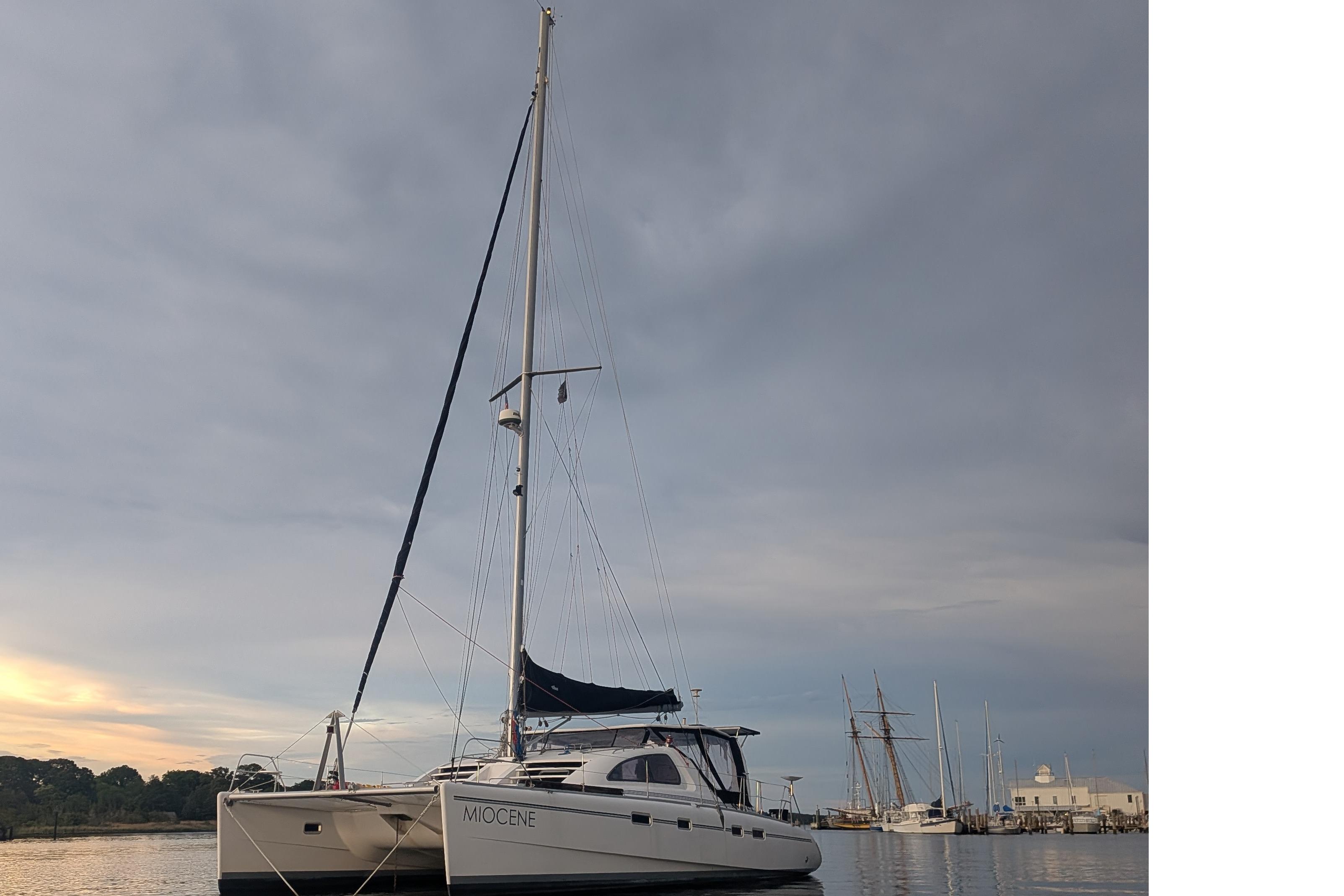 2001 Robertson & Caine Leopard catamaran docked at a marina under a cloudy sky.
