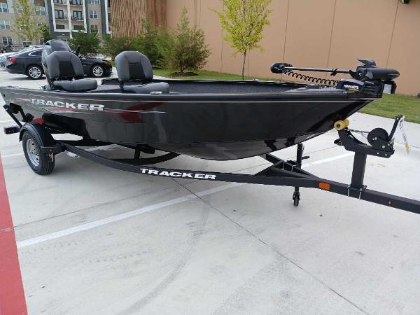 2025 Tracker Super Guide V-16 T boat on trailer in parking lot.