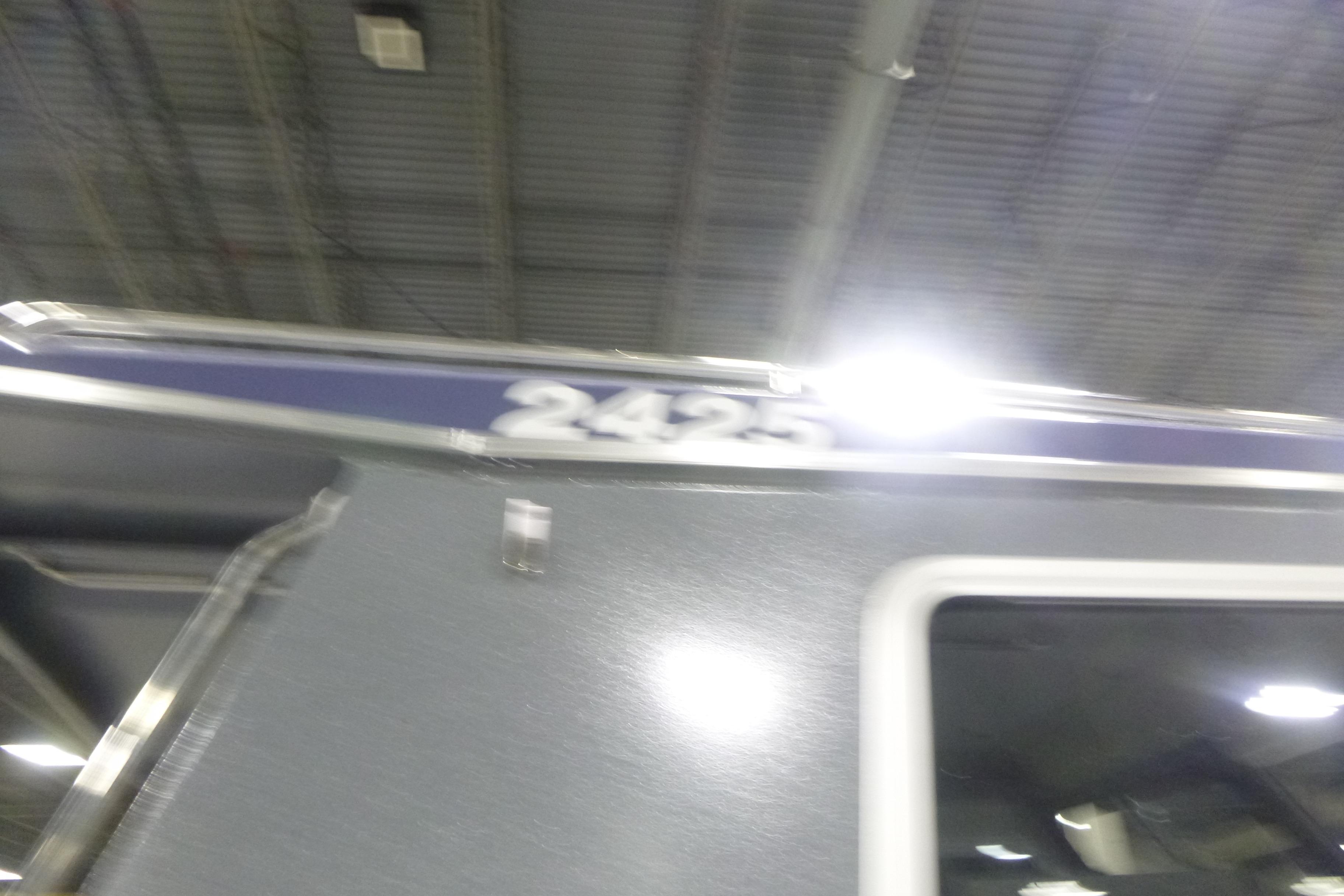 Blurry image of KingFisher 2425 Escape HT boat under bright lights.