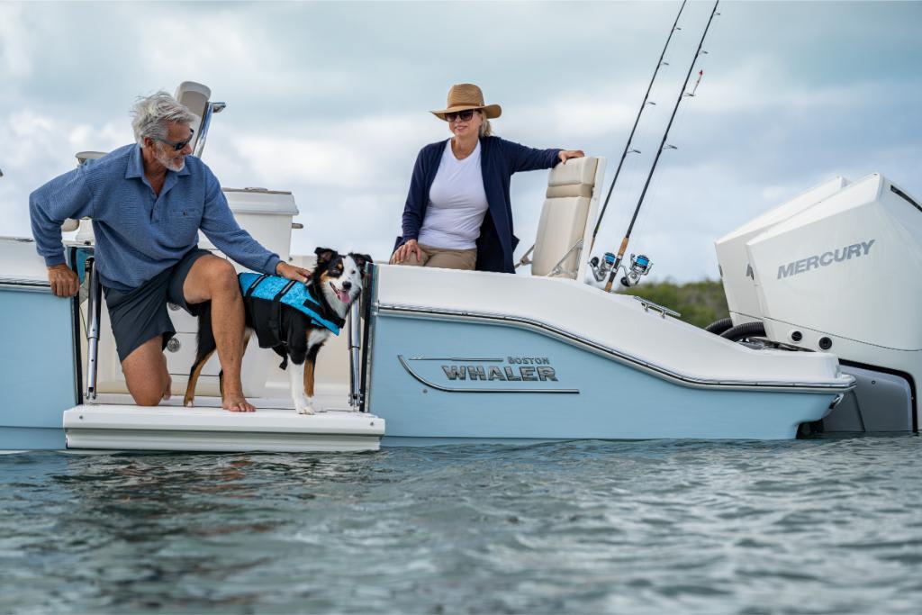 2024 Boston Whaler 280 Dauntless boat with people and dog on water.