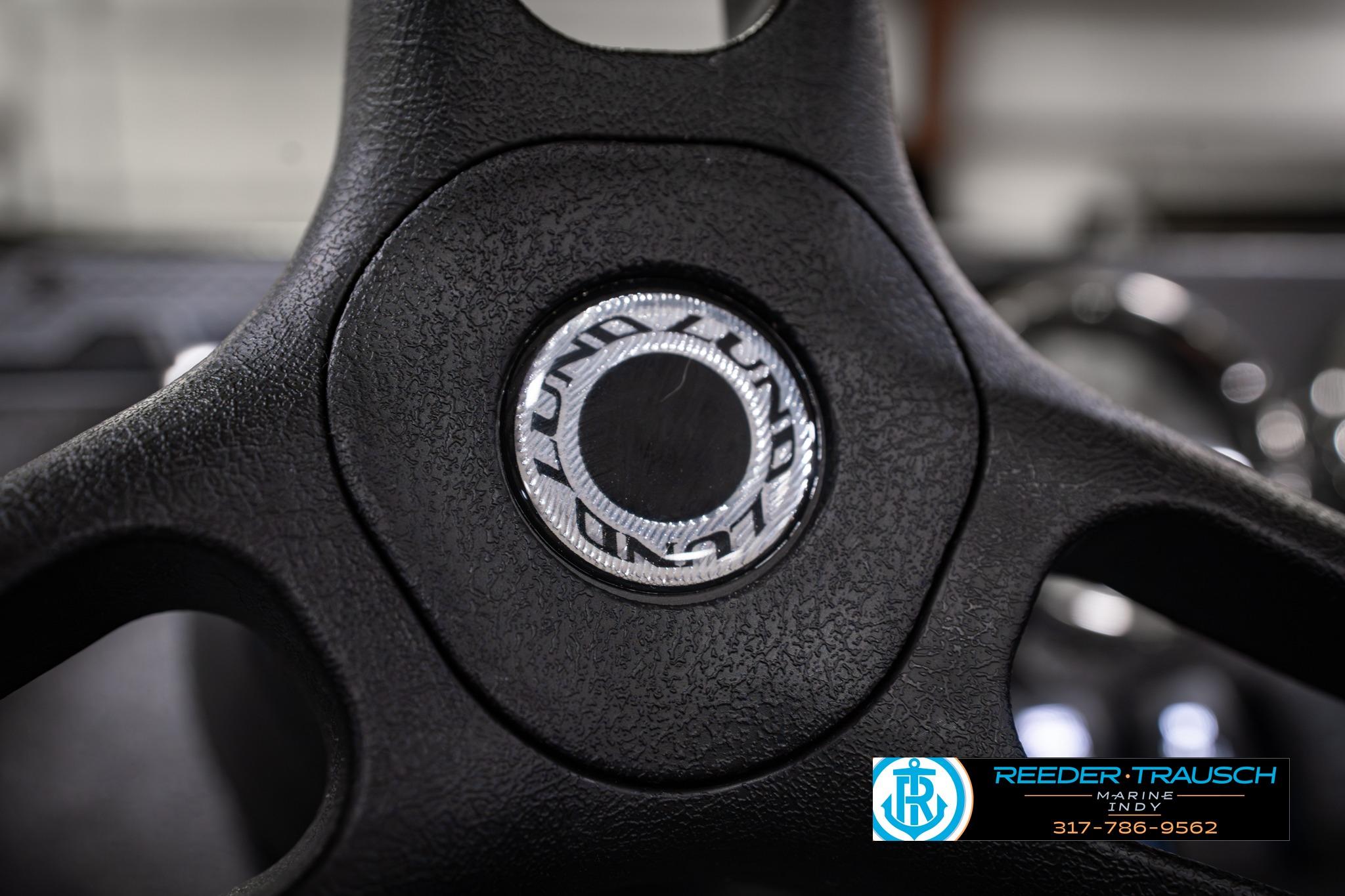 Steering wheel of 2026 Lund 1650 Rebel XL SS boat, featuring logo detail.