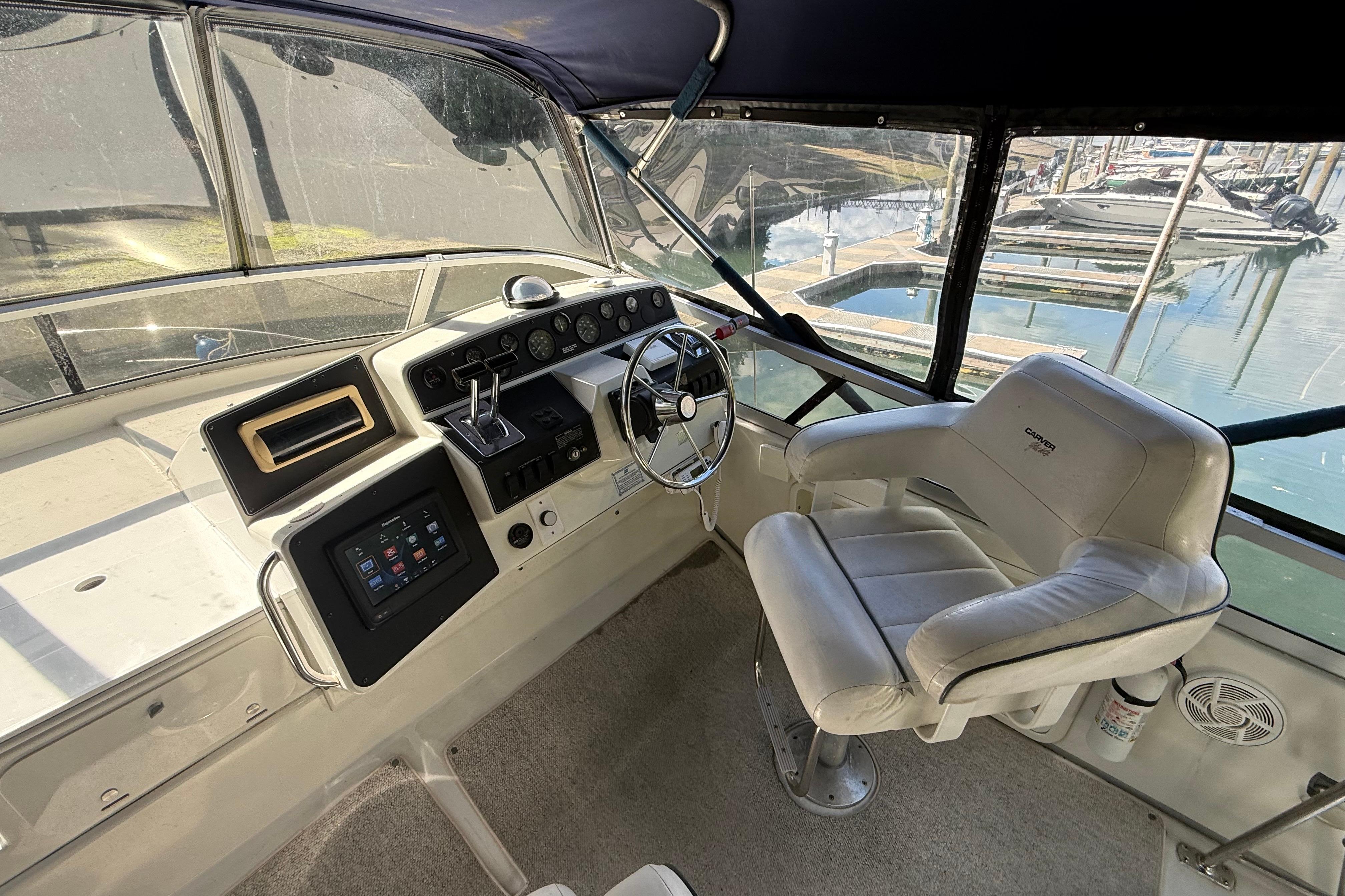 1995 Carver 370 Voyager helm with steering wheel, control panel, and captain's chair.