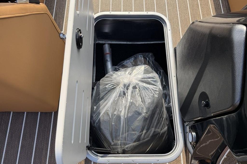 Storage compartment in 2026 Premier 250 Solaris RS CL boat, featuring a plastic-covered item.