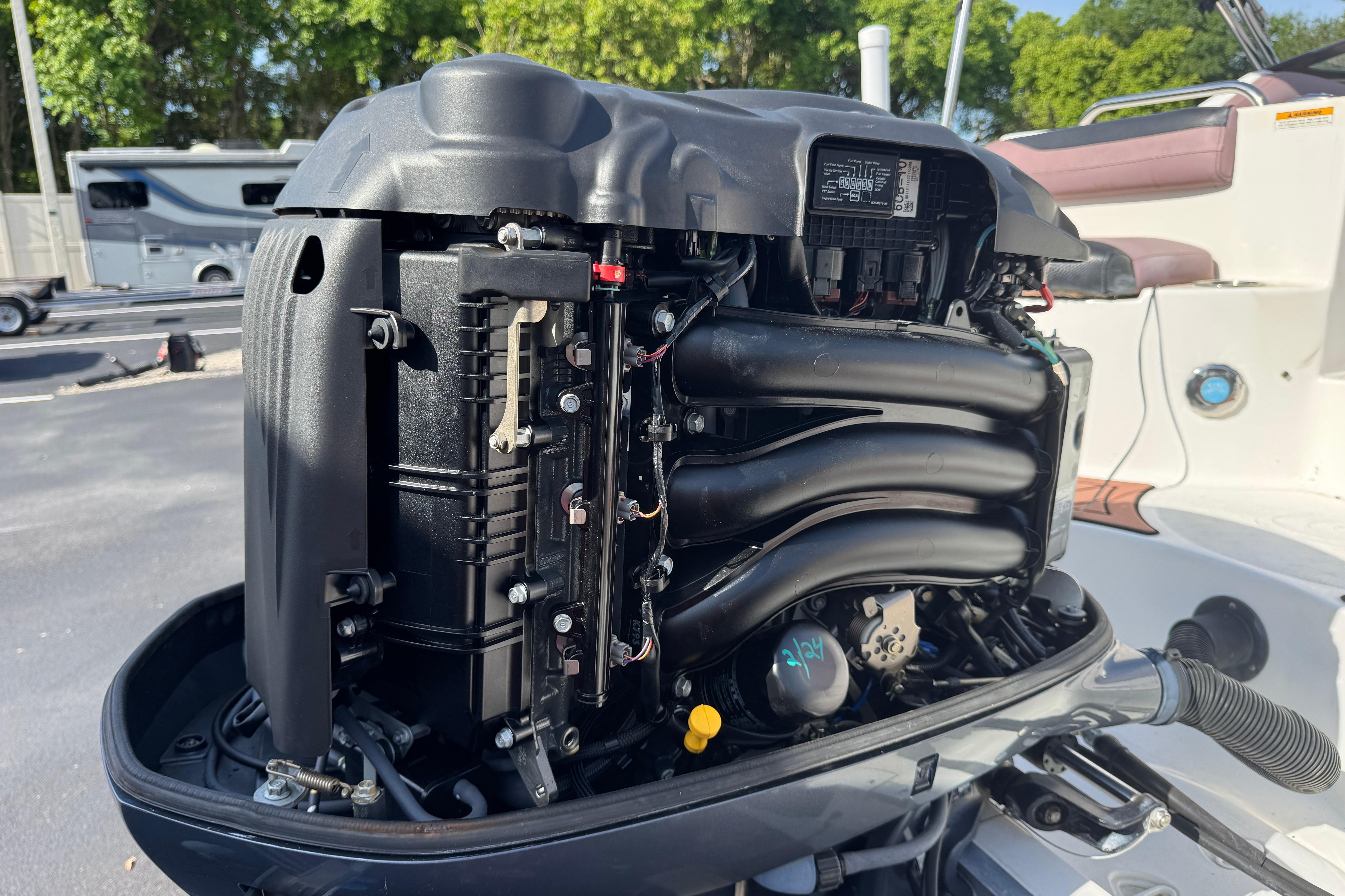 2018 Hurricane SunDeck 2400 OB outboard engine, detailed view, parked outdoors.