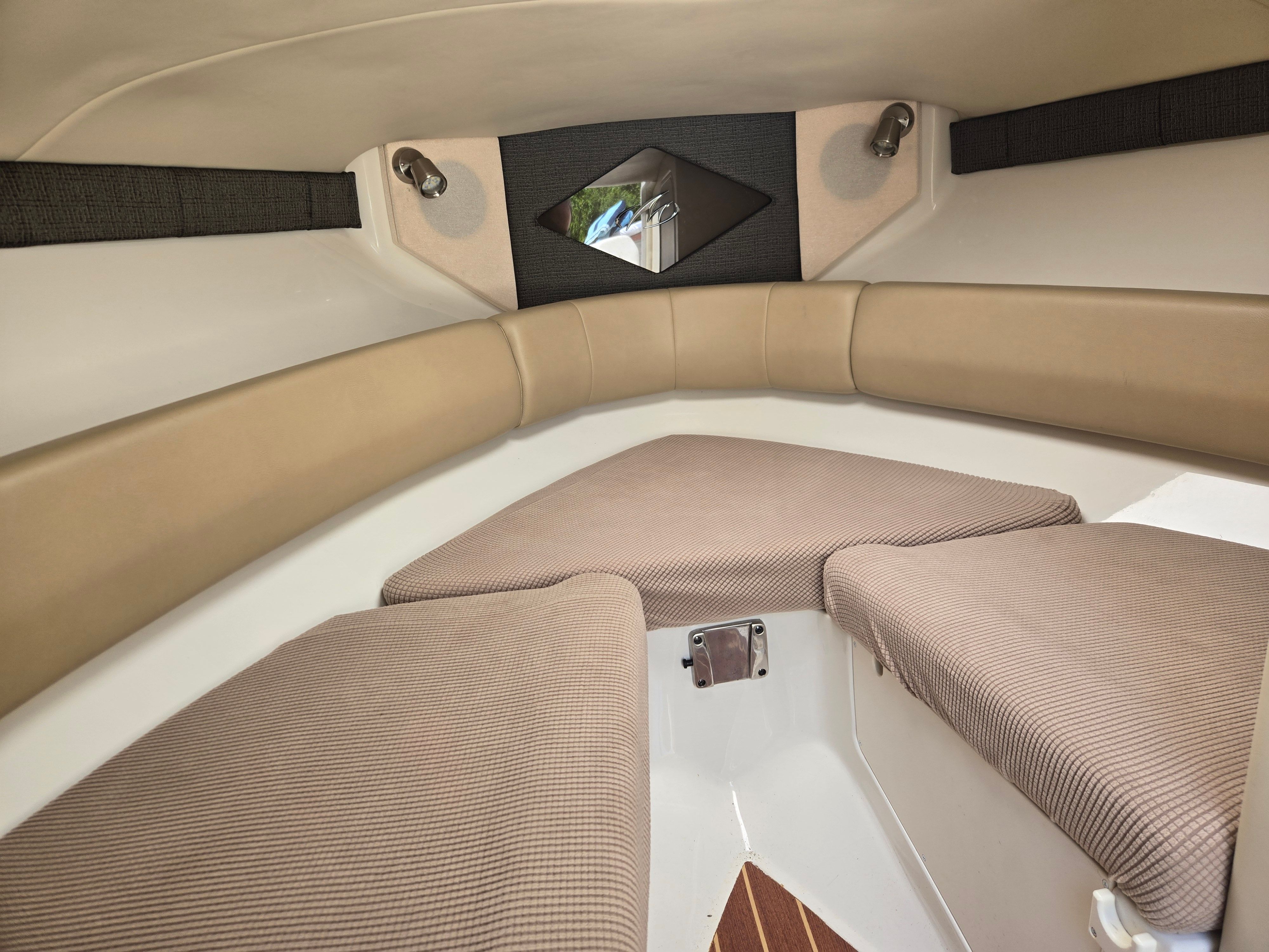Interior of a Monterey 264 with cushioned seating and a small window.