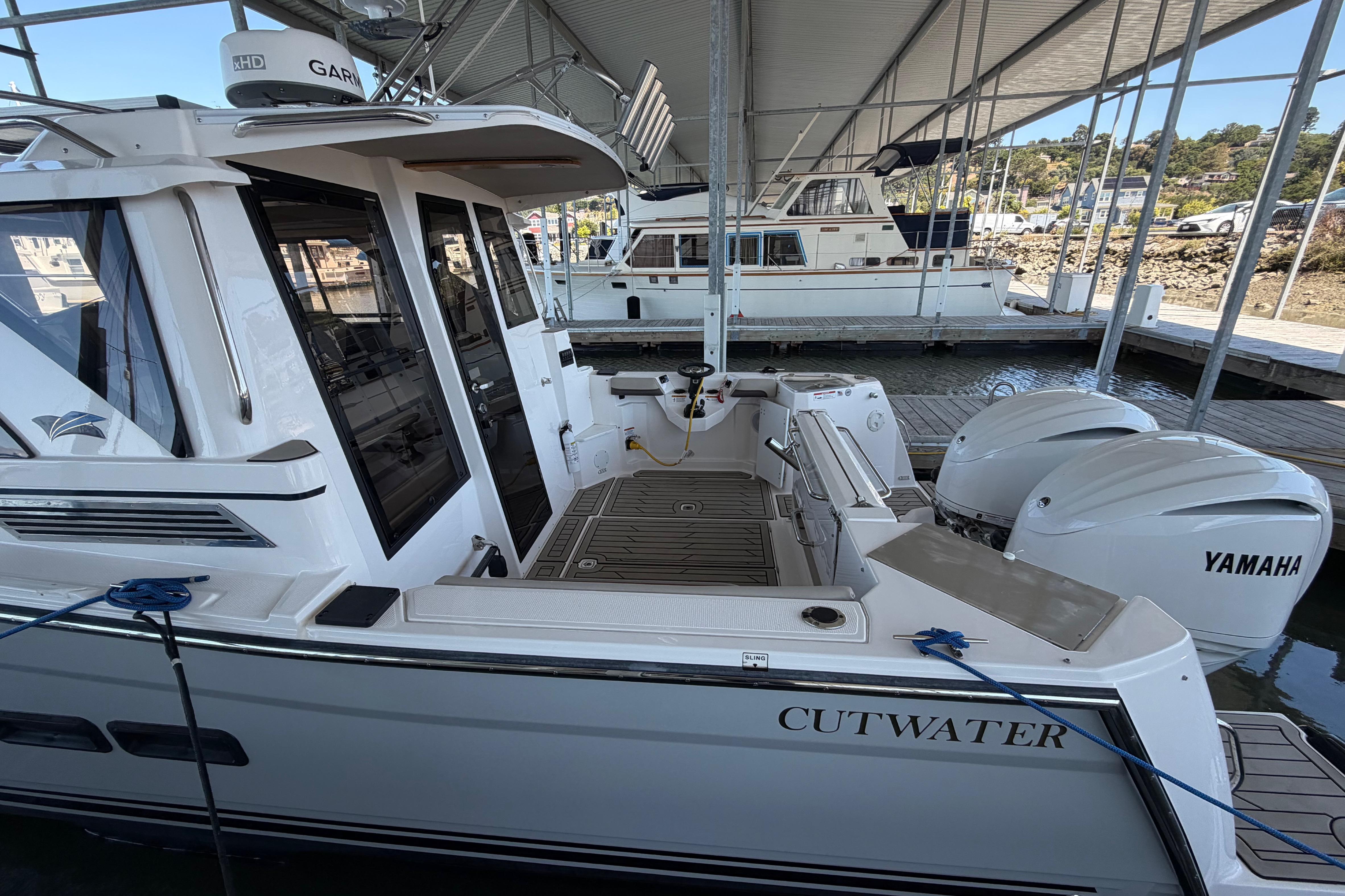 2023 Cutwater C-288 Coupe docked, featuring dual Yamaha outboard engines under a covered marina.