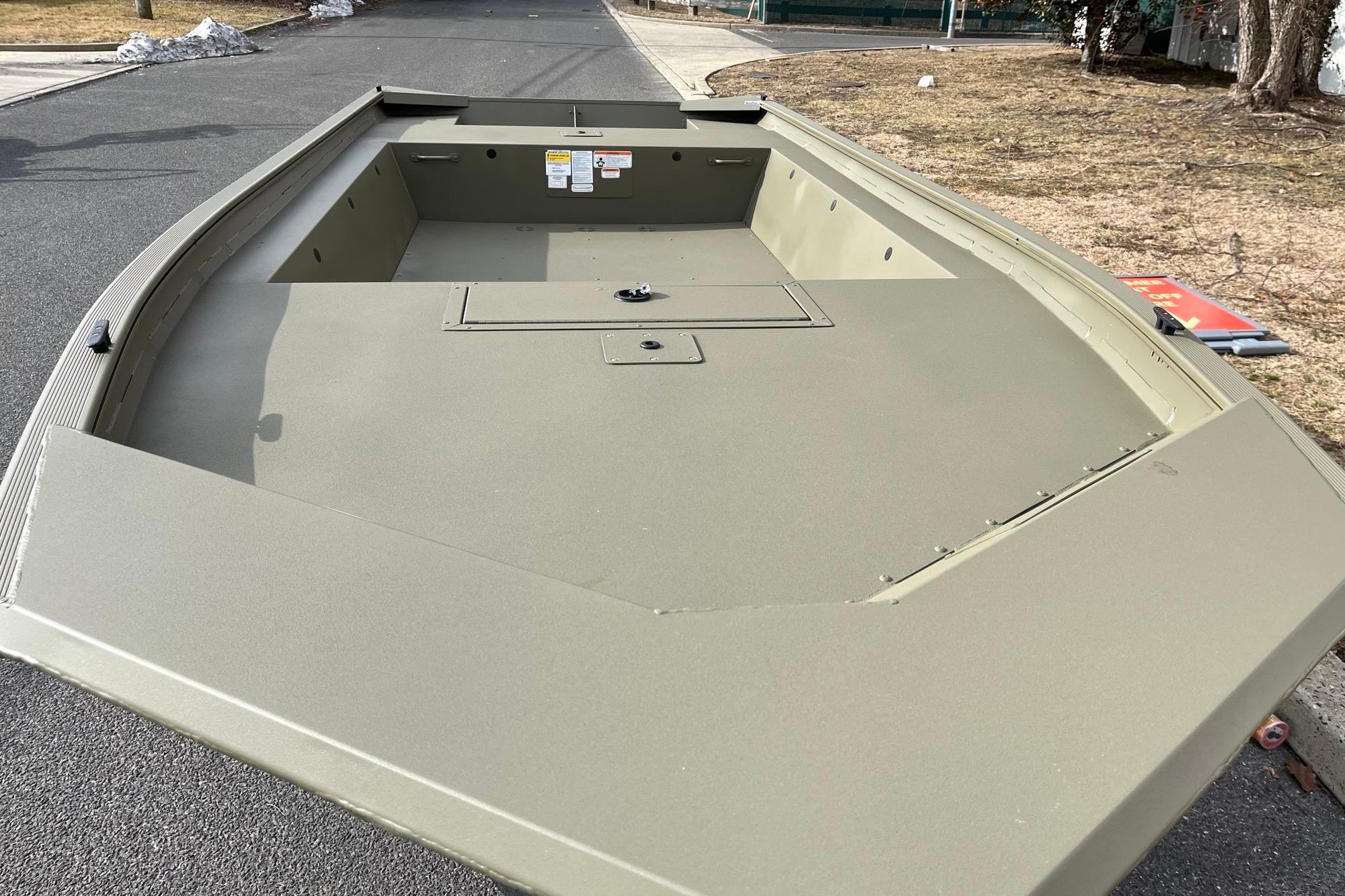 2026 Tracker Grizzly 1754 Utility boat on pavement, showcasing spacious interior design.