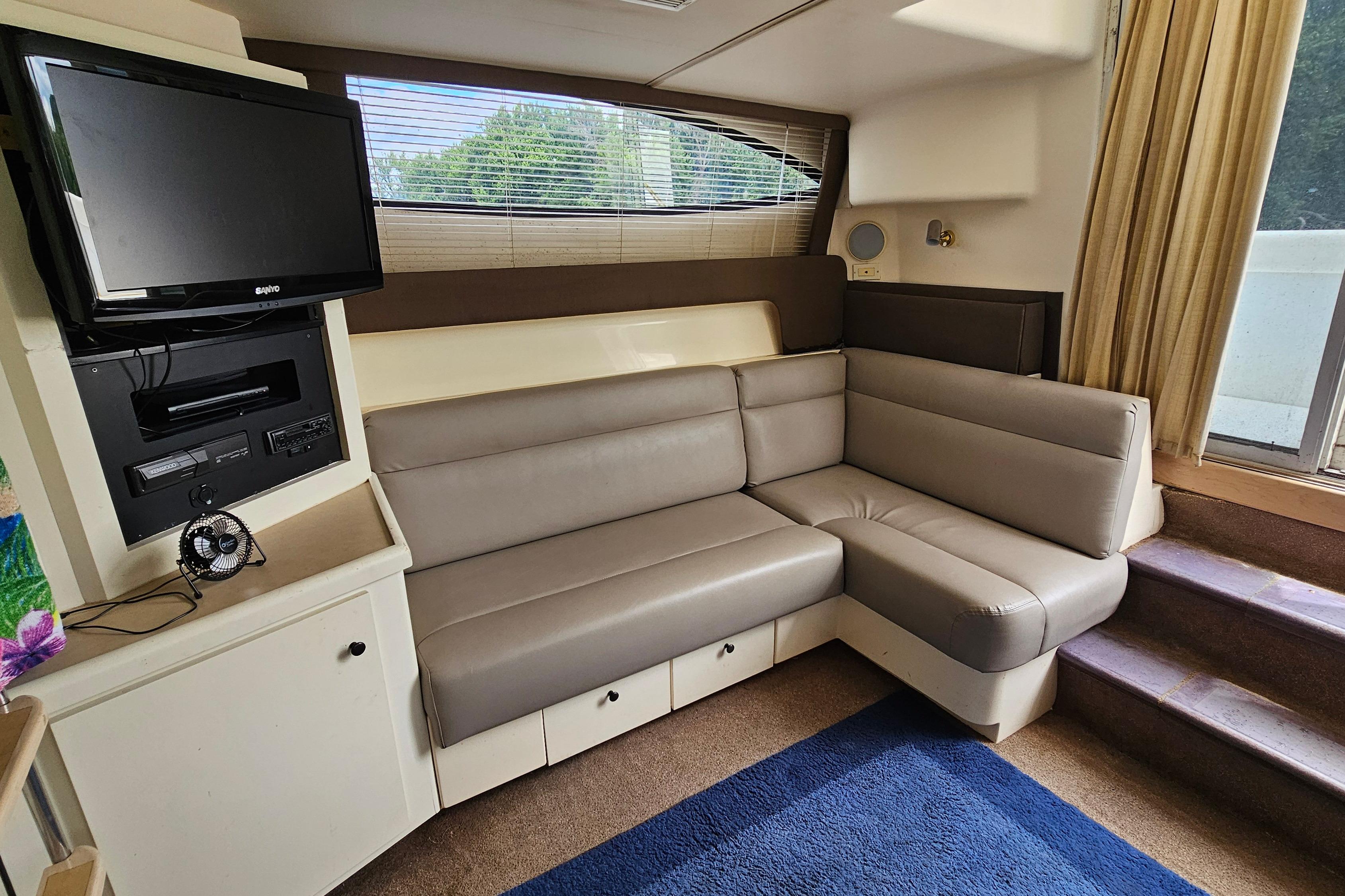 Interior of 1999 Carver 350 Mariner yacht with cozy seating and entertainment area.