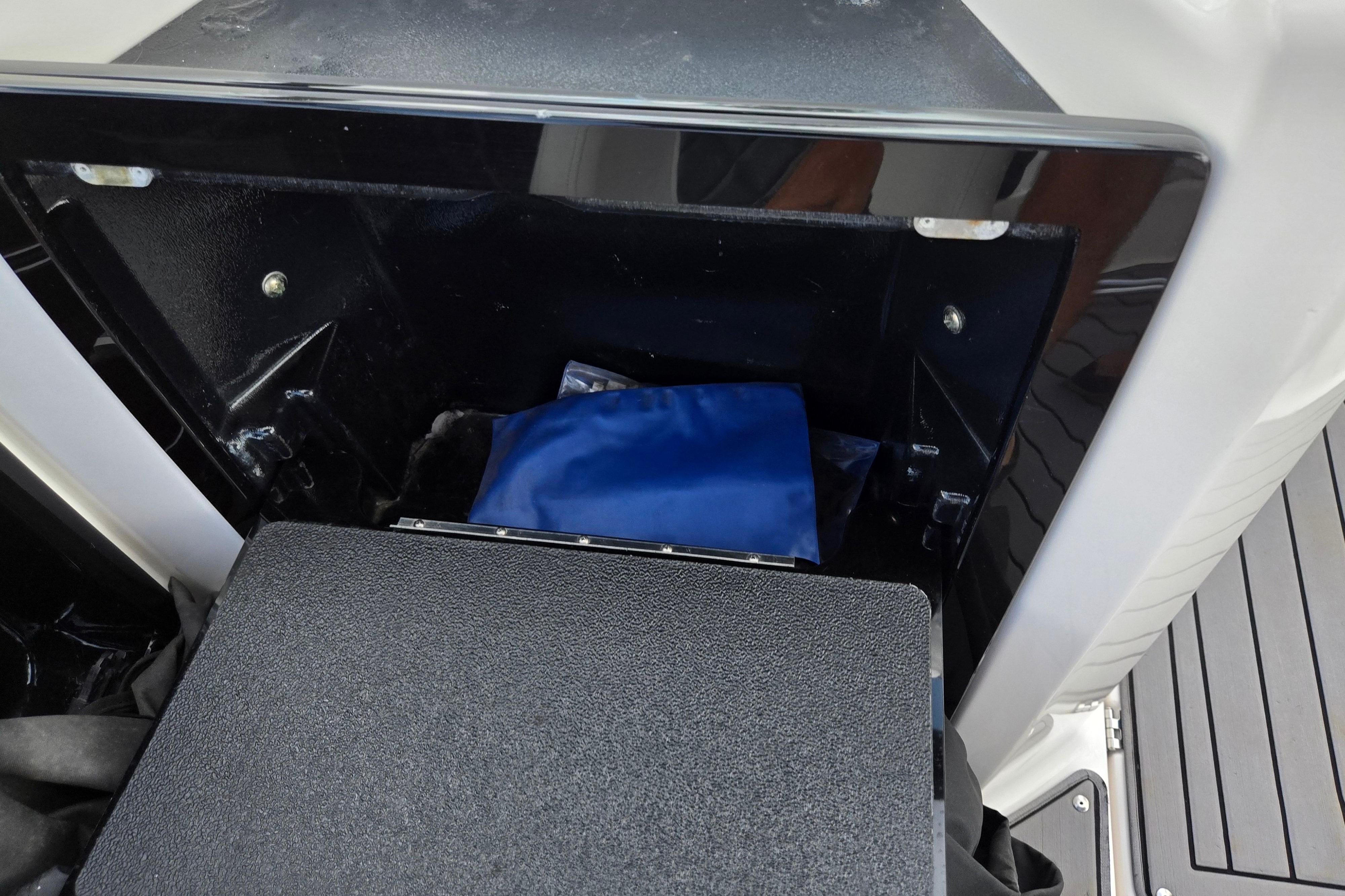 Storage compartment in 2018 Yamaha Boats 212X, featuring a blue bag inside.