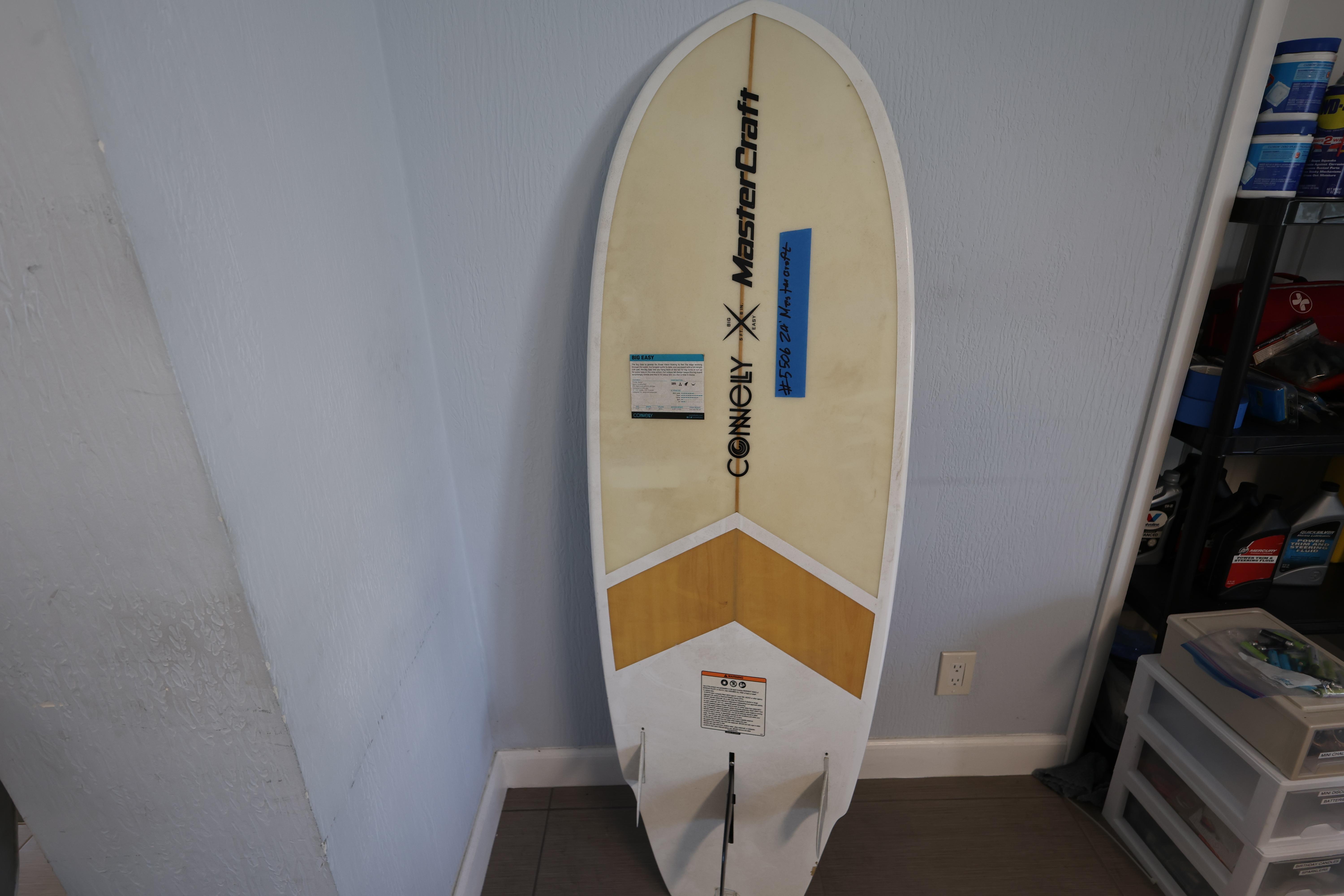 2023 MasterCraft X24 surfboard by Connelly, leaning against a wall in a garage.