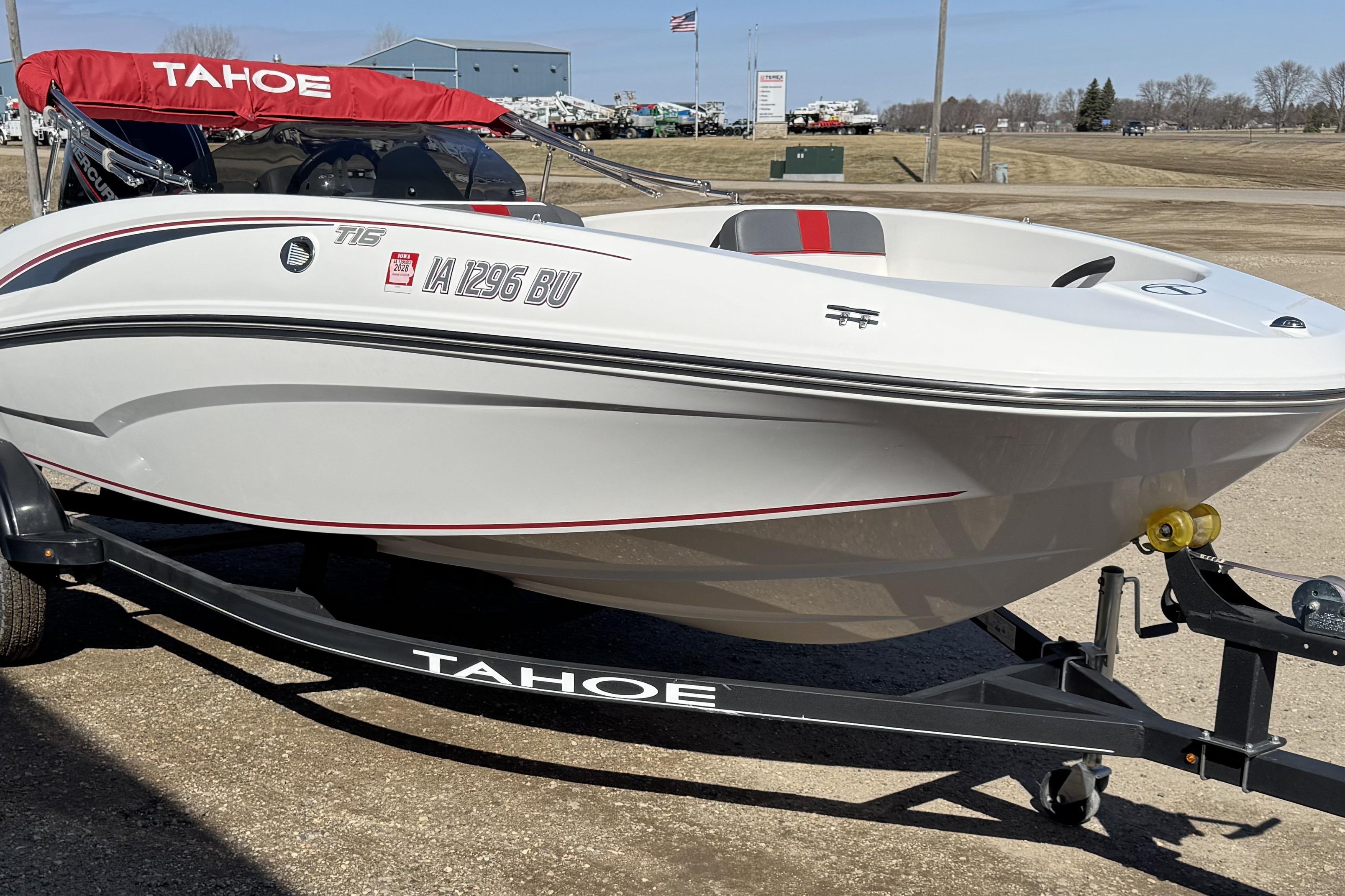 2021 Tahoe T16 boat on trailer with red canopy, parked outdoors.